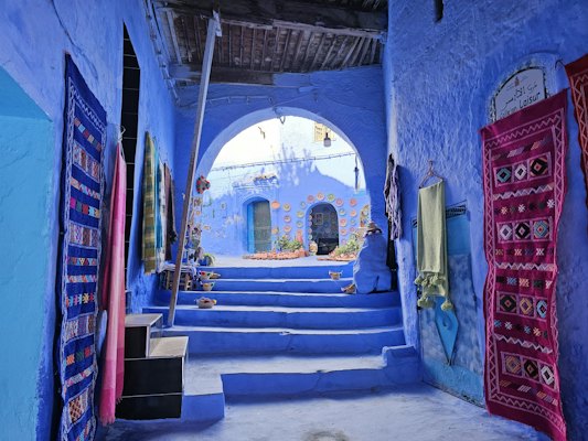 Blue alley with stairs and hanging rugs — Chefchaouen, Morocco