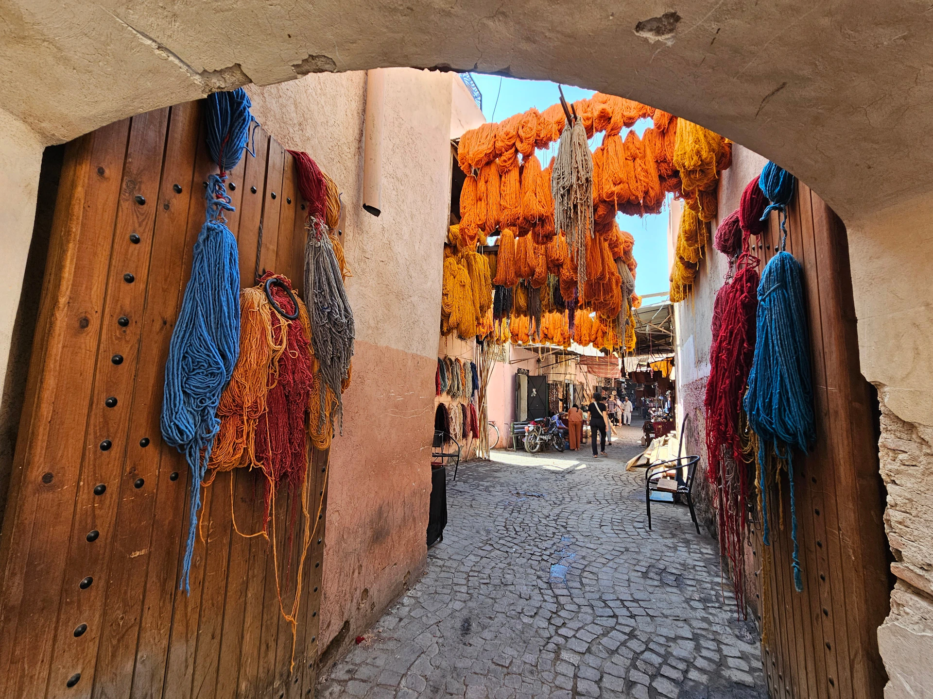 Colorful yarn hanging in a moroccan market alleyway