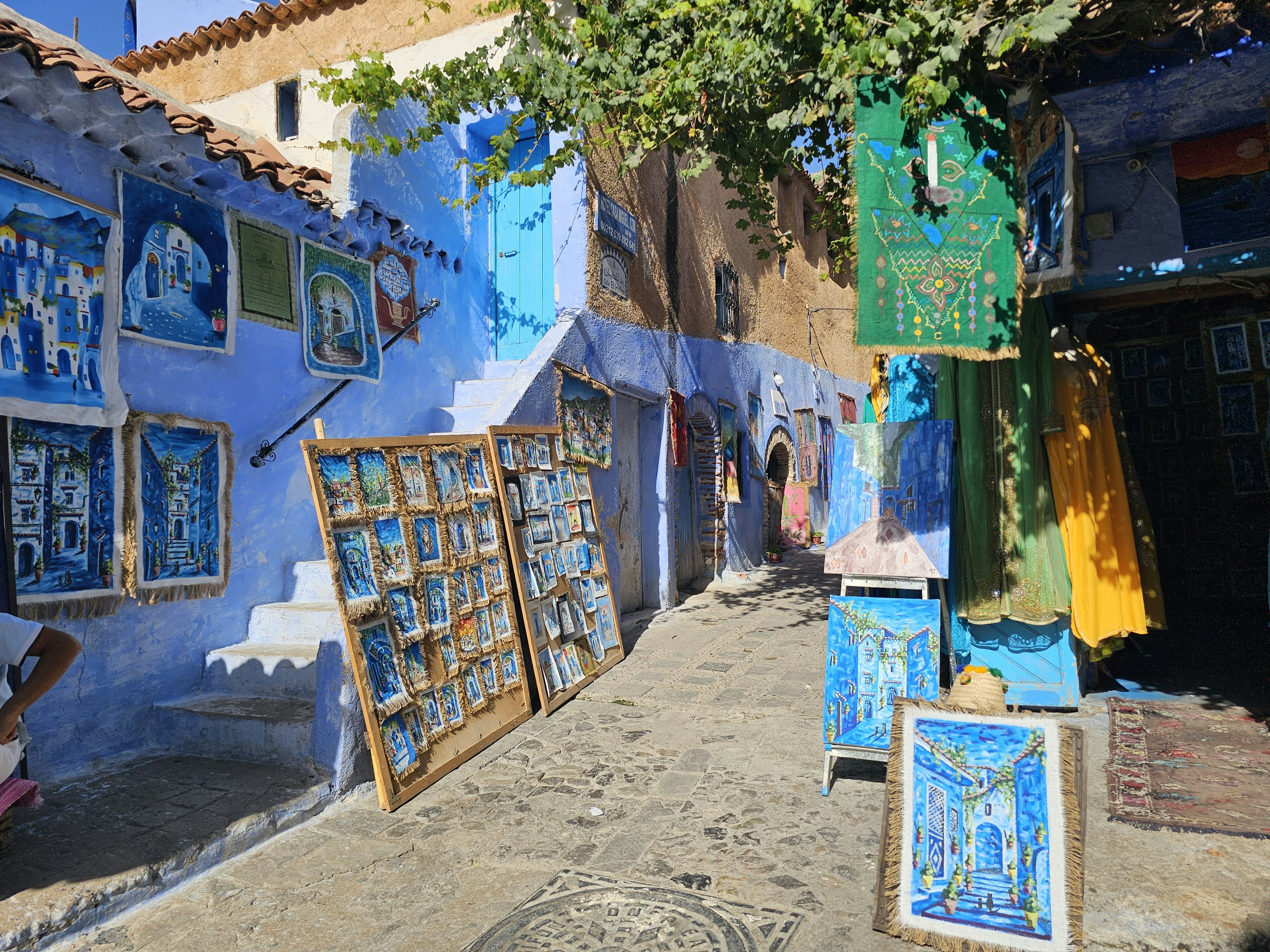 A narrow, vibrant blue alleyway in Chefchaouen's historic medina, with traditional Moroccan architecture.