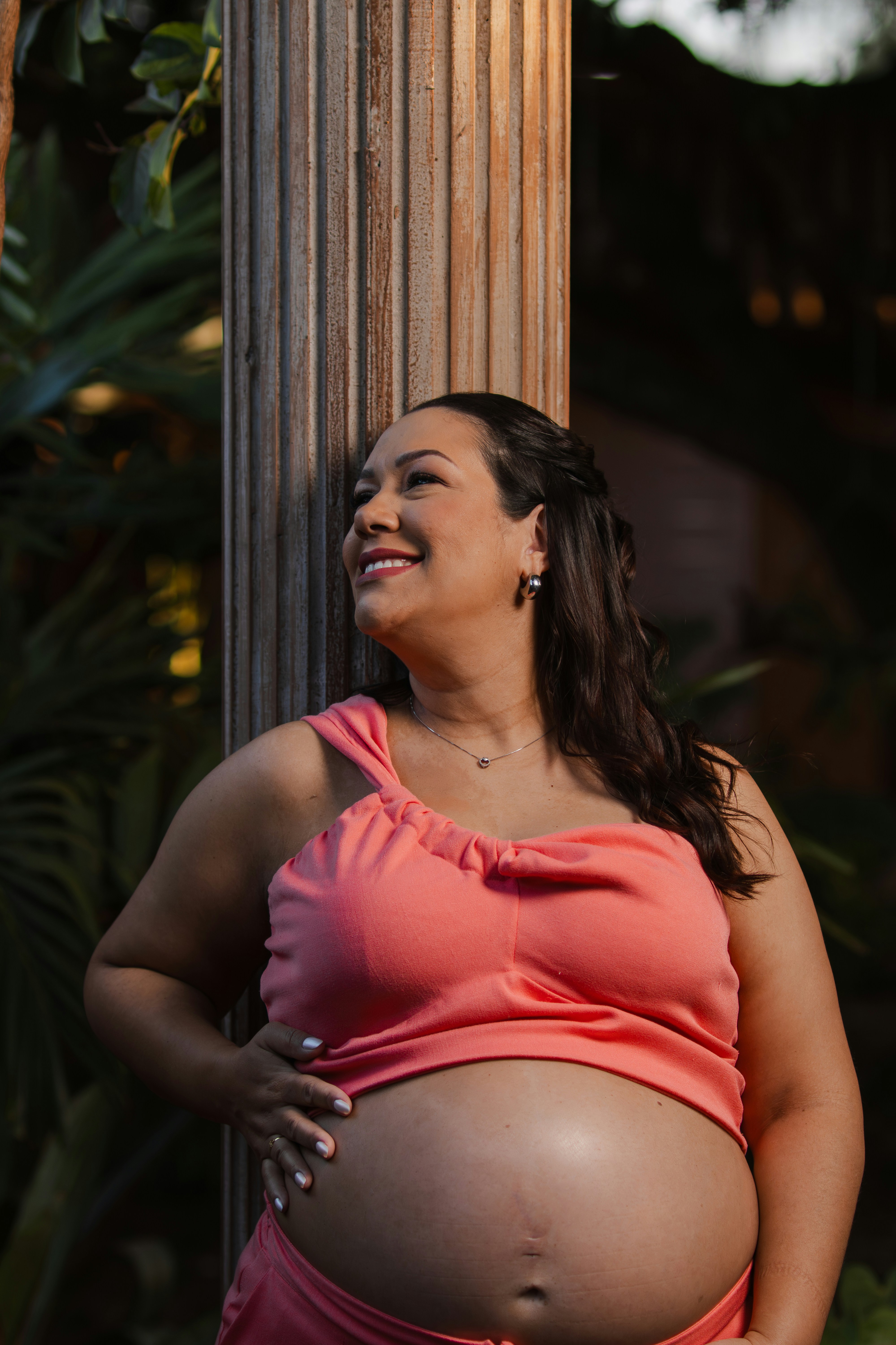 Pregnant woman smiling and looking away outdoors