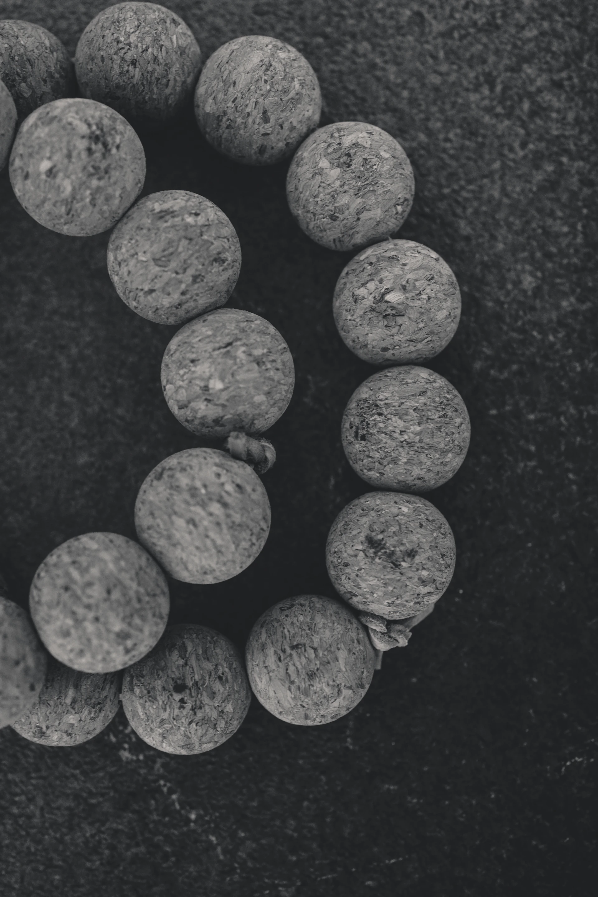 A strand of round stone beads on dark surface
