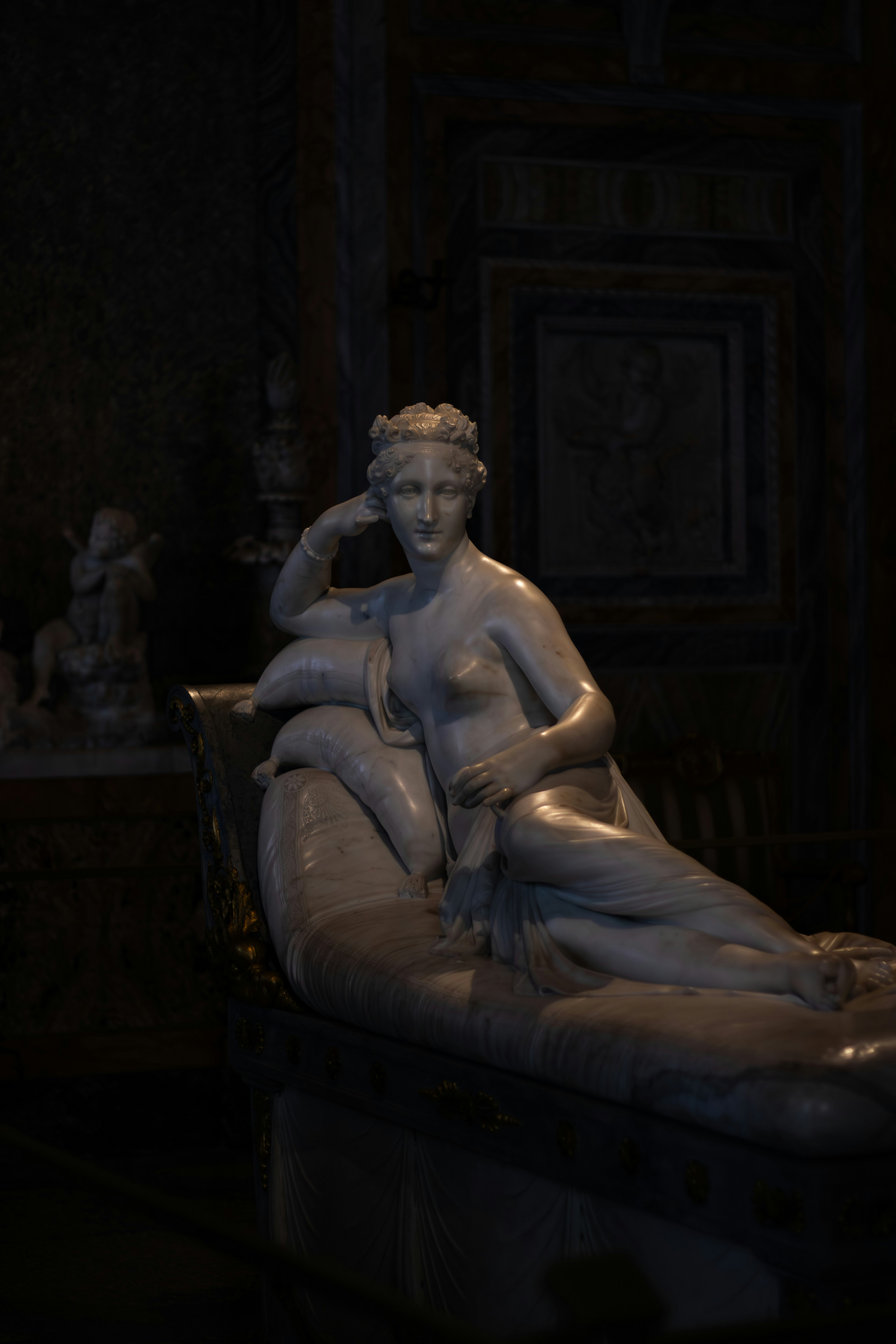 Marble sculpture of a reclining nude woman on chaise lounge