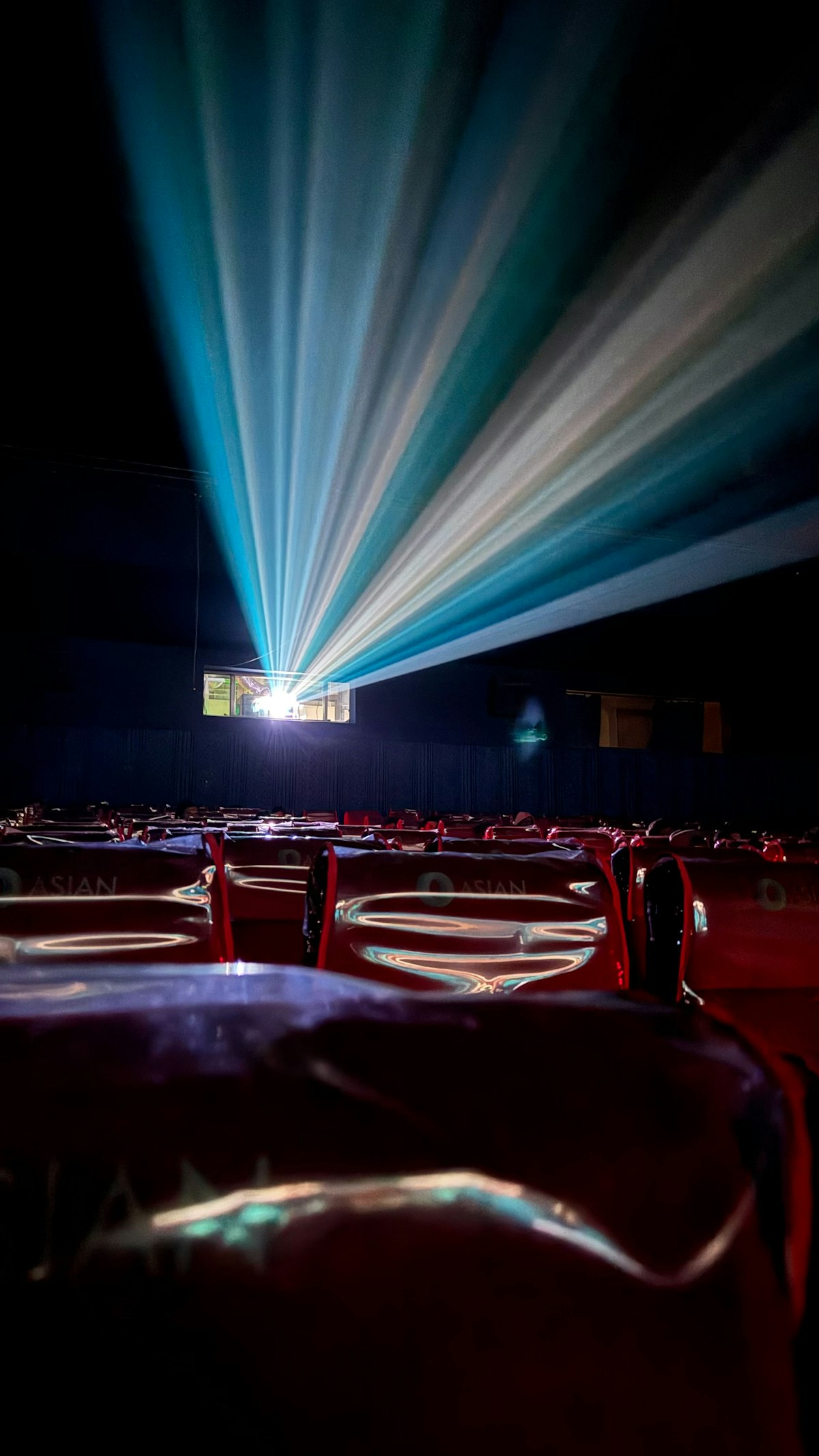Salle de cinéma obscure éclairée par le faisceau du projecteur