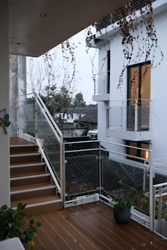 Modern staircase with glass railings and wooden deck