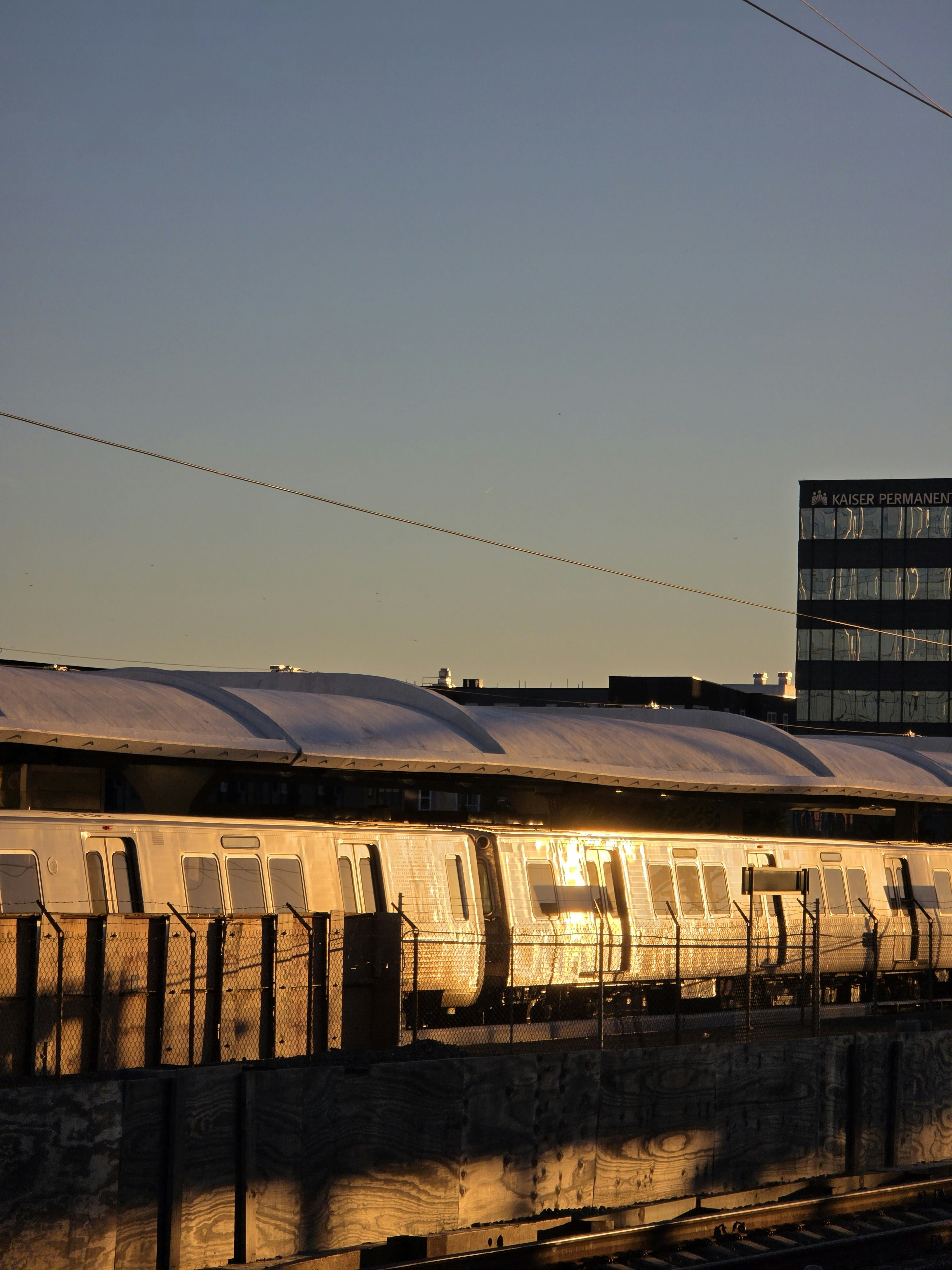 Train at station reflecting golden hour sunlight.