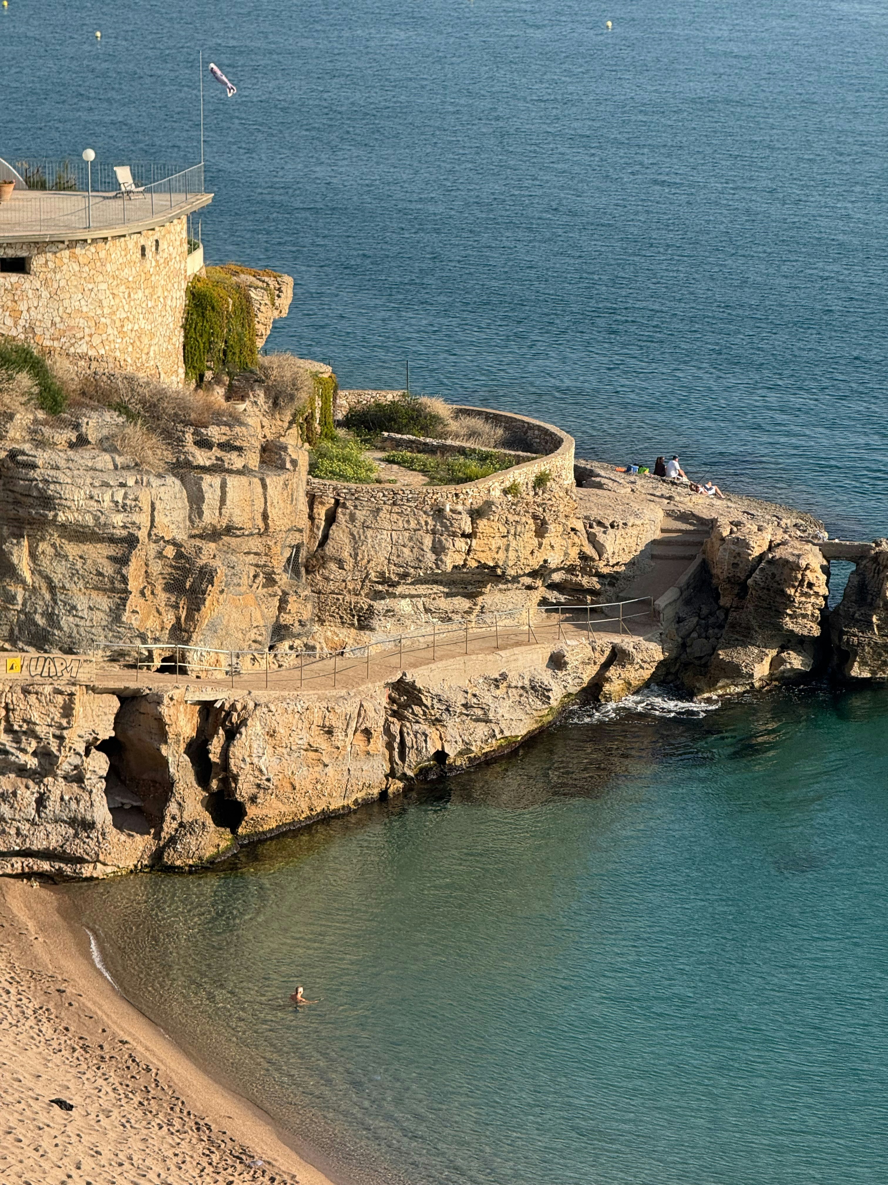 바다가 내려다보이는 건물이 있는 바위가 많은 해안선.