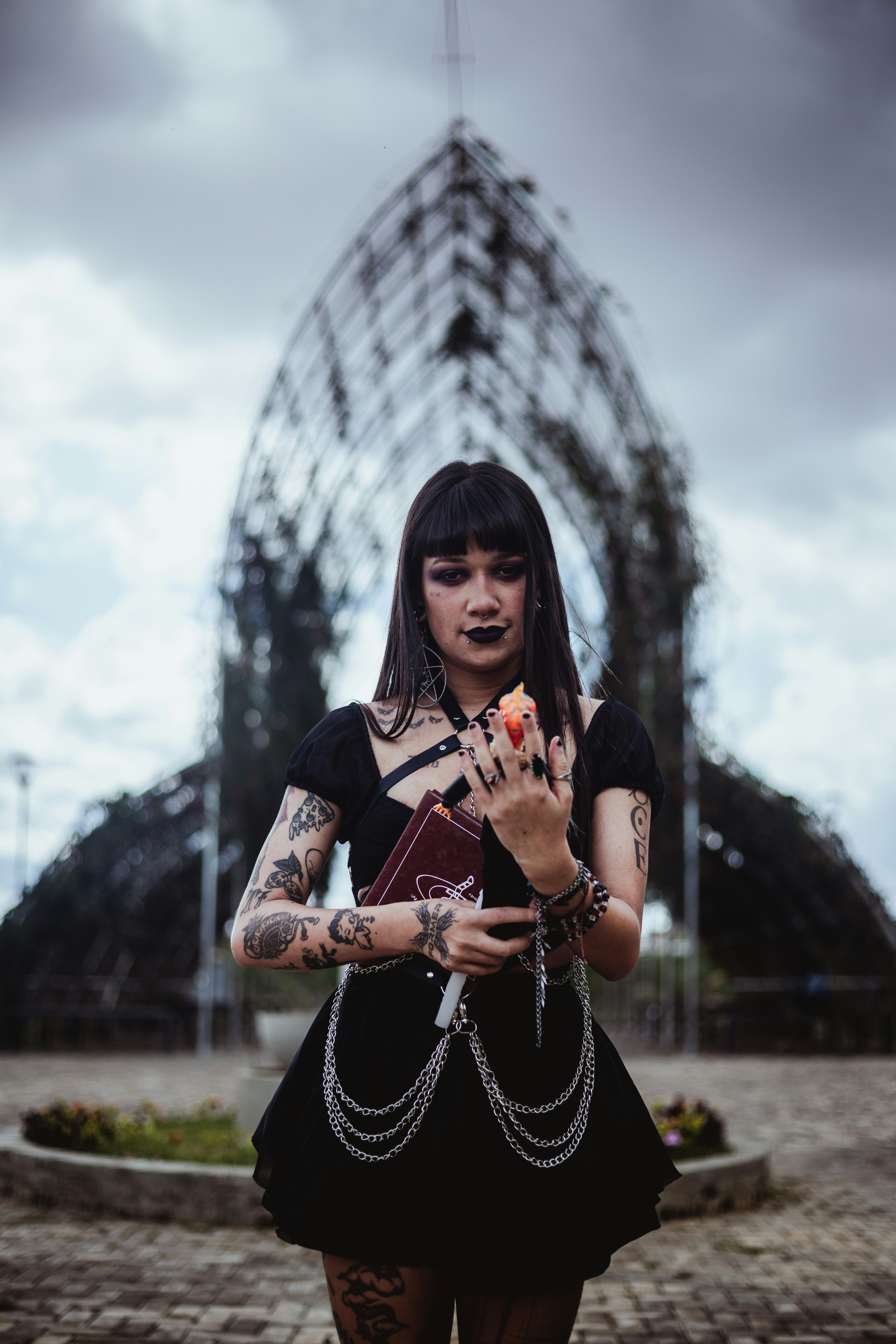 Mulher gótica segurando uma maçã na frente da estrutura do arco