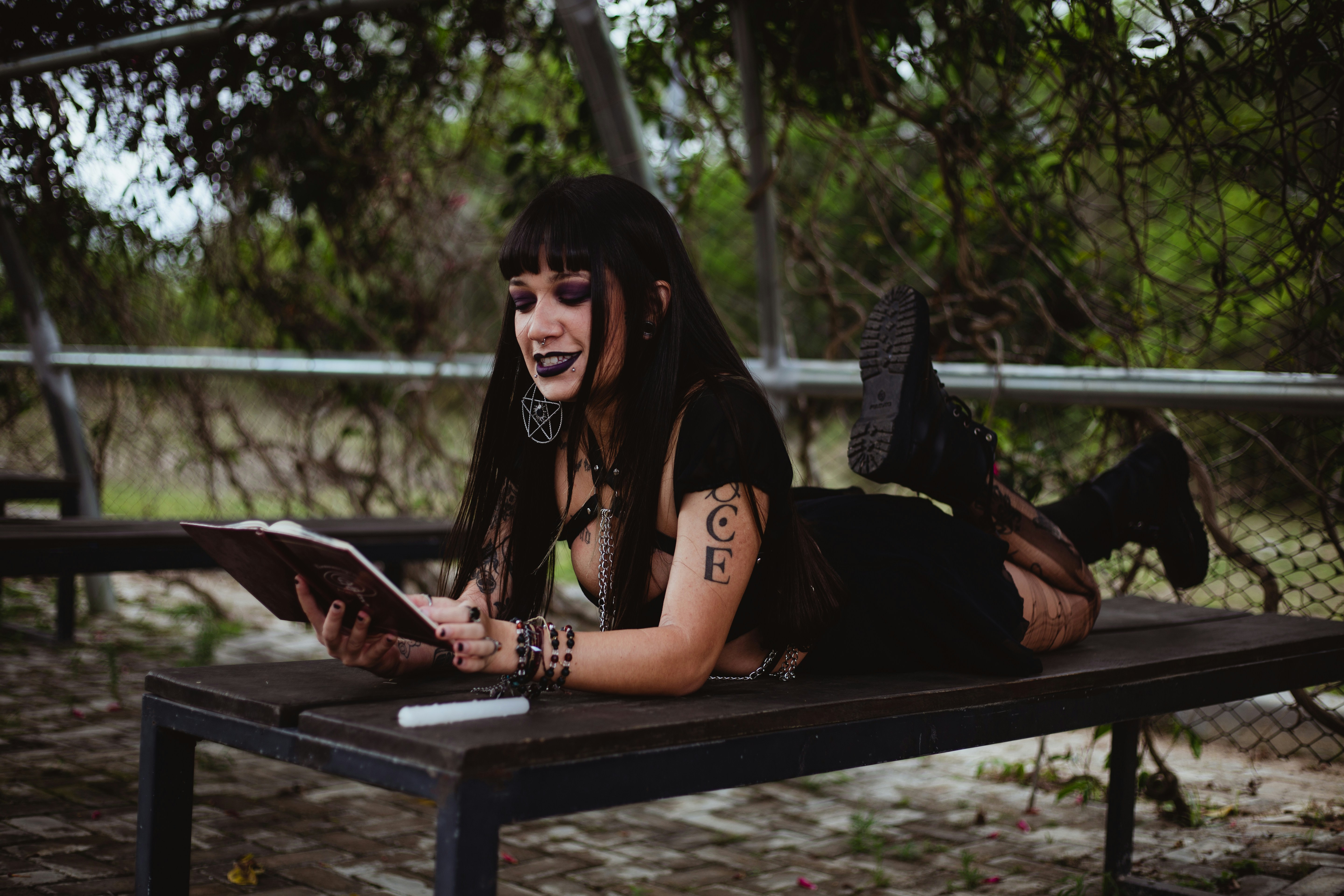 Woman with dark hair reading a book outdoors