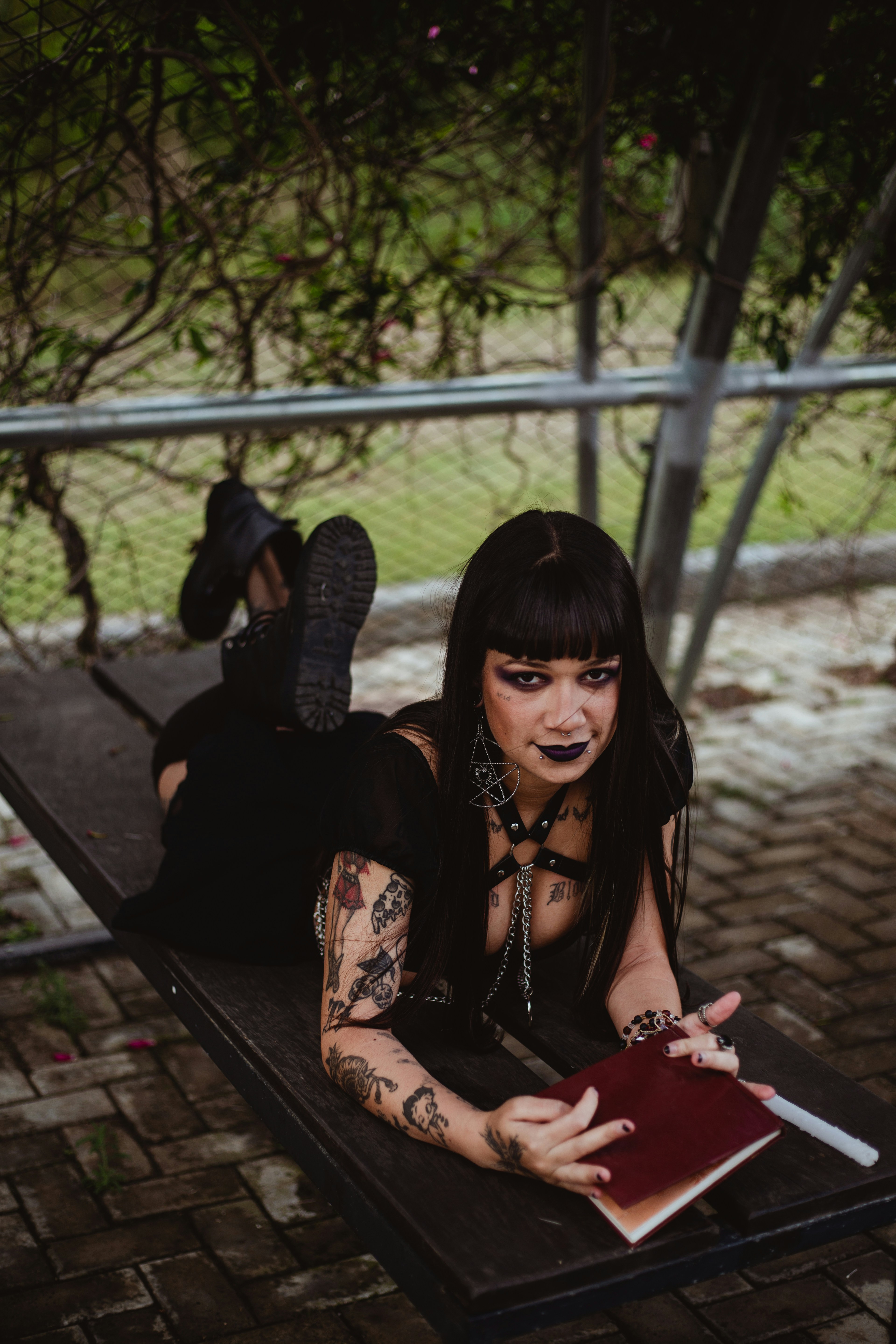Woman in dark clothing with tattoos lying down