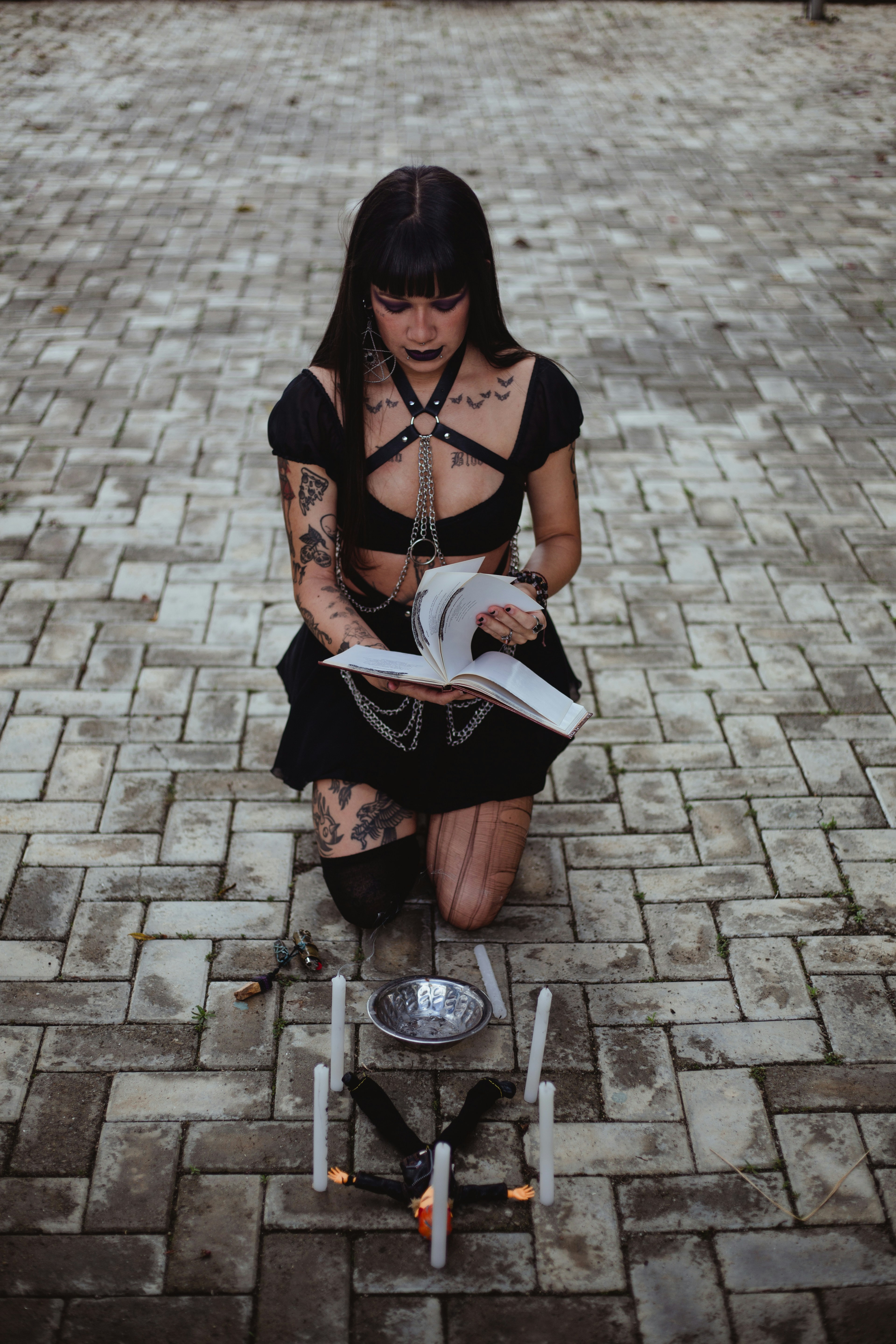 Woman in dark attire reading a book outdoors