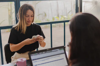 Two women working at a desk with a laptop.