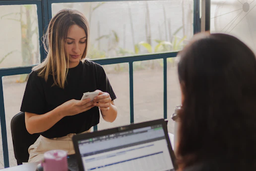 Two women working at a desk with a laptop.