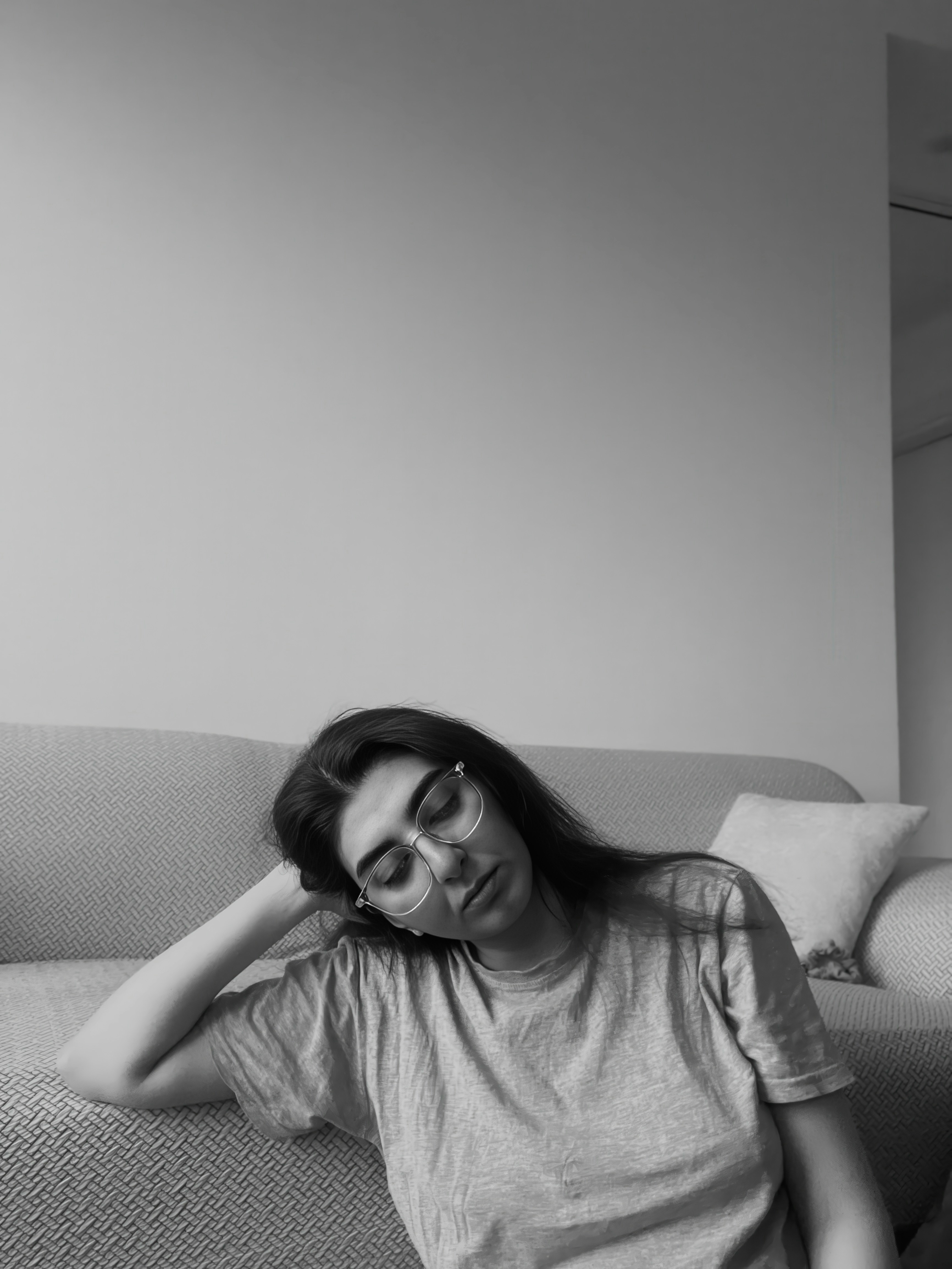 Woman with glasses resting head on arm