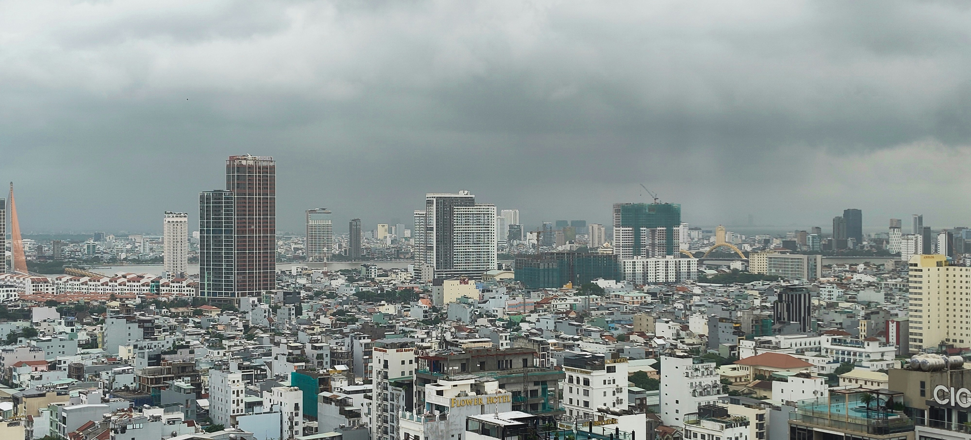 Paysage urbain avec des bâtiments denses sous un ciel nuageux.