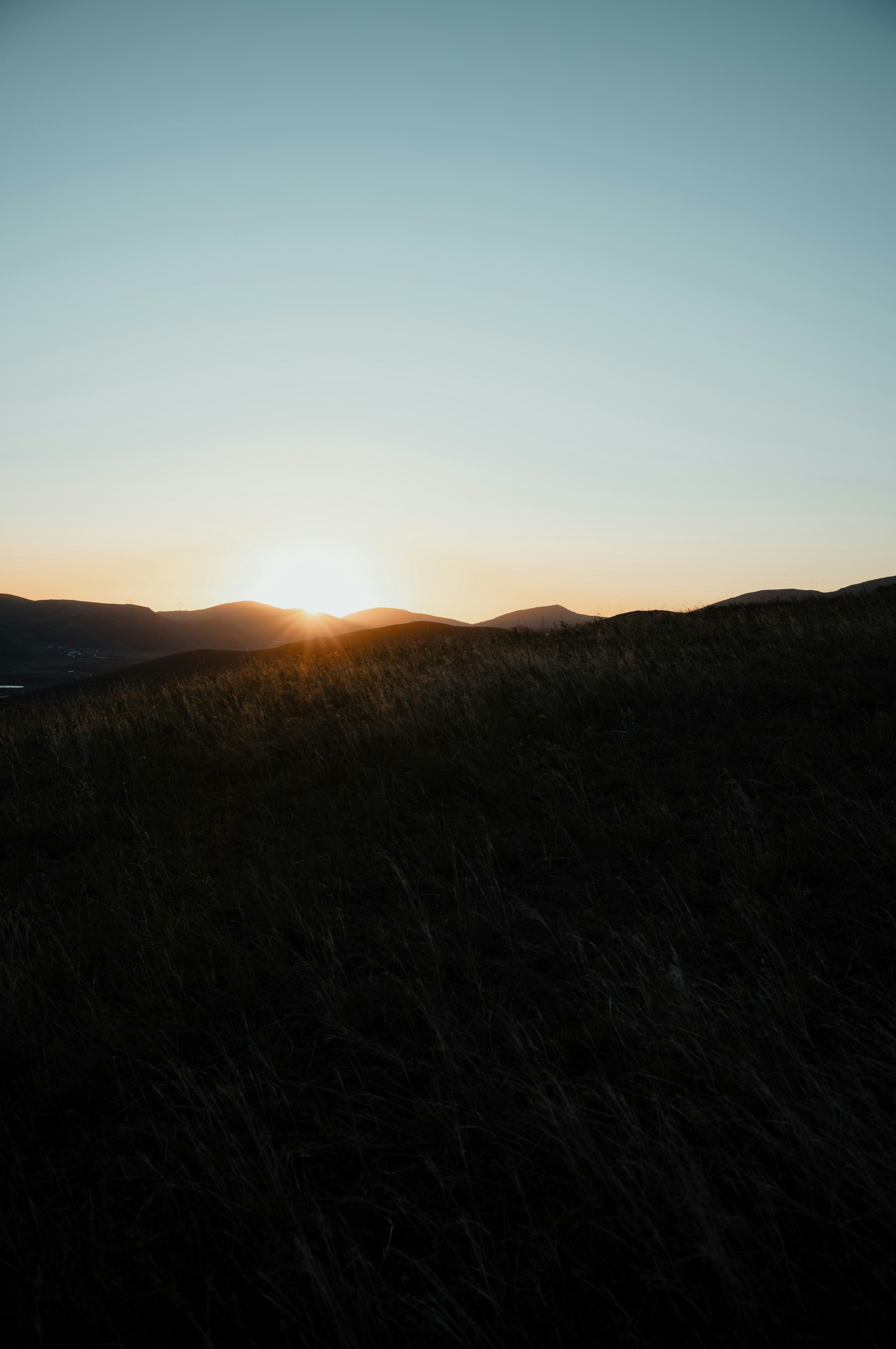 Sunset over rolling hills with tall grass