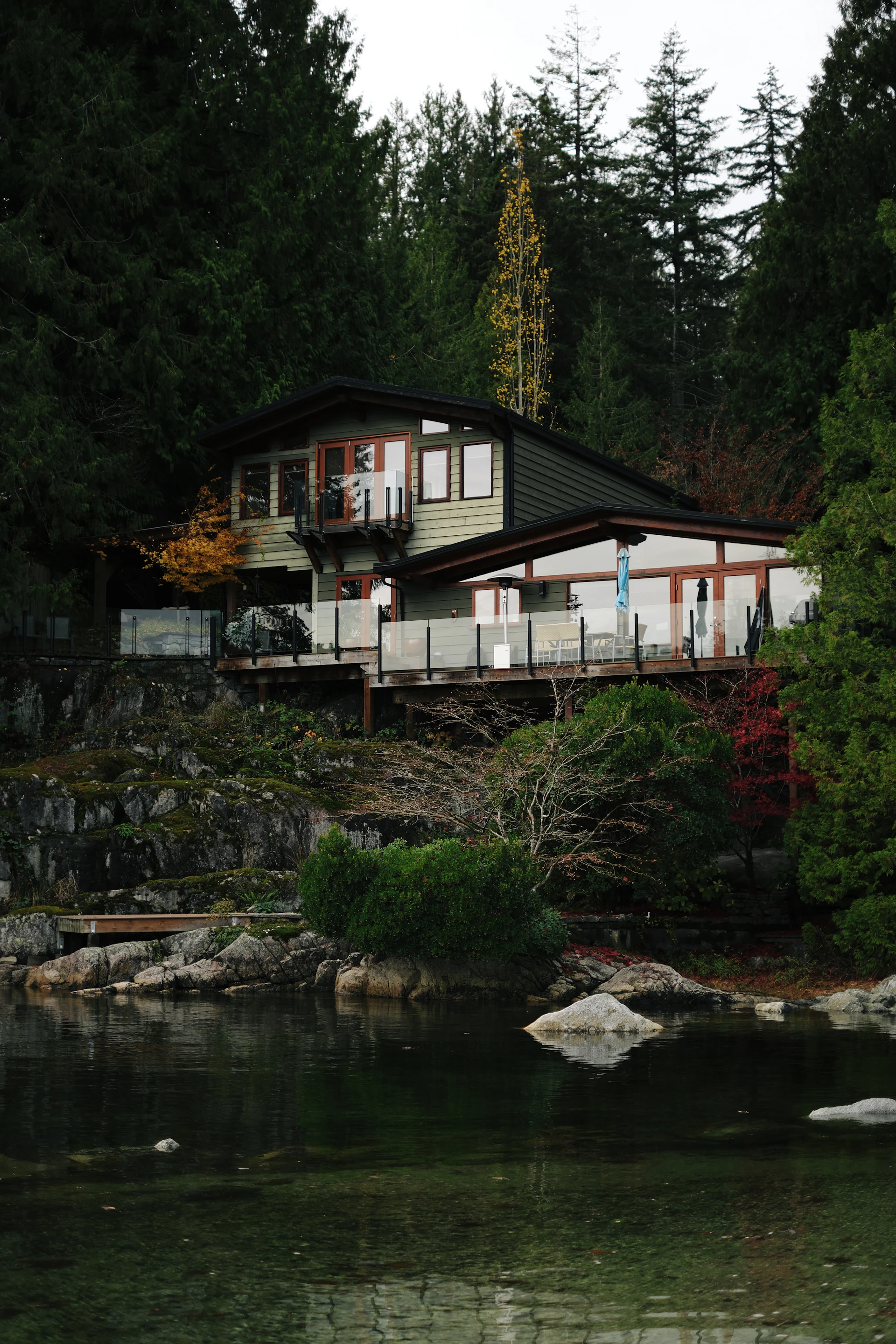 Okanagan lake house with a glass-railed deck overlooking the water