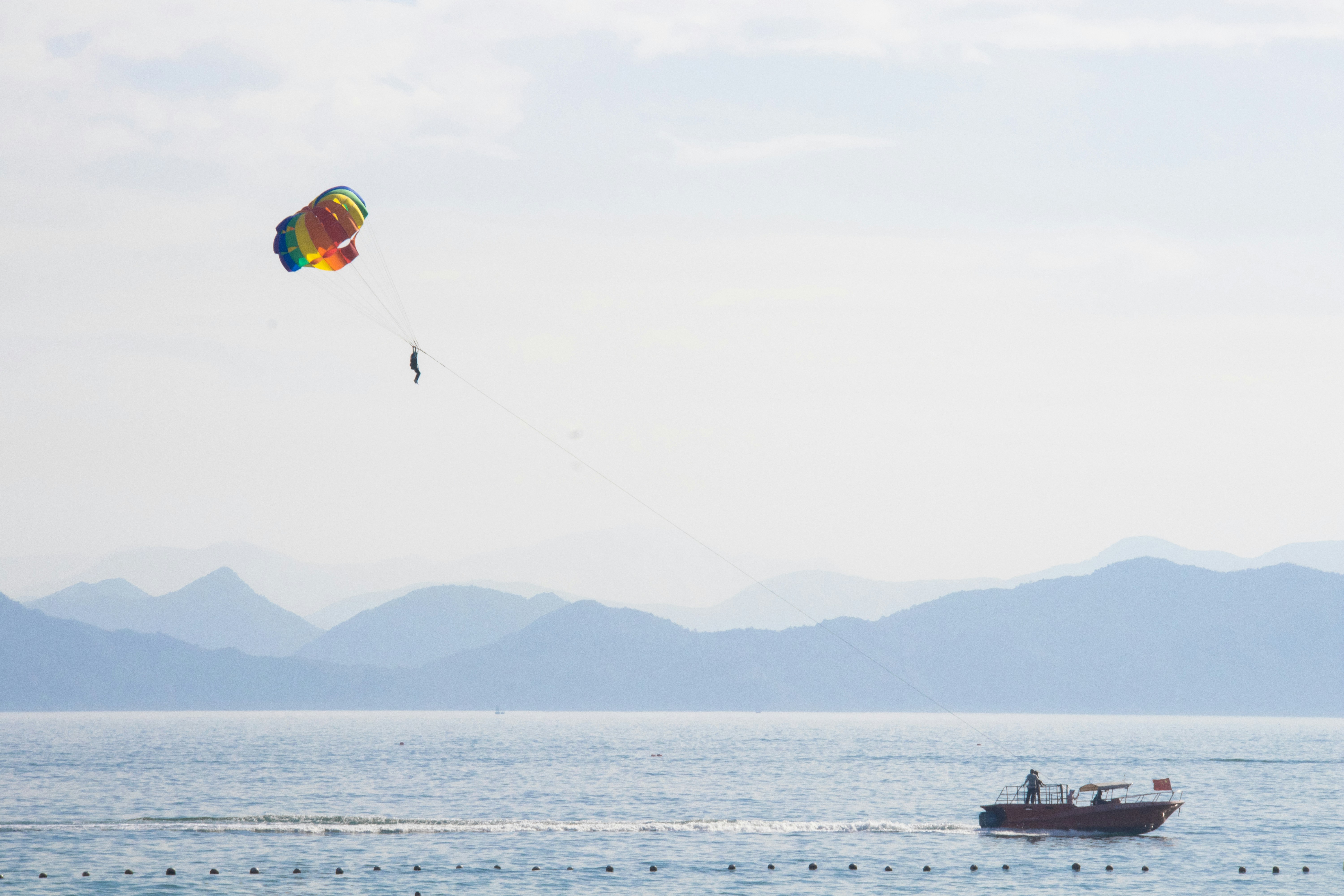 Parasailing over the ocean with a boat below.