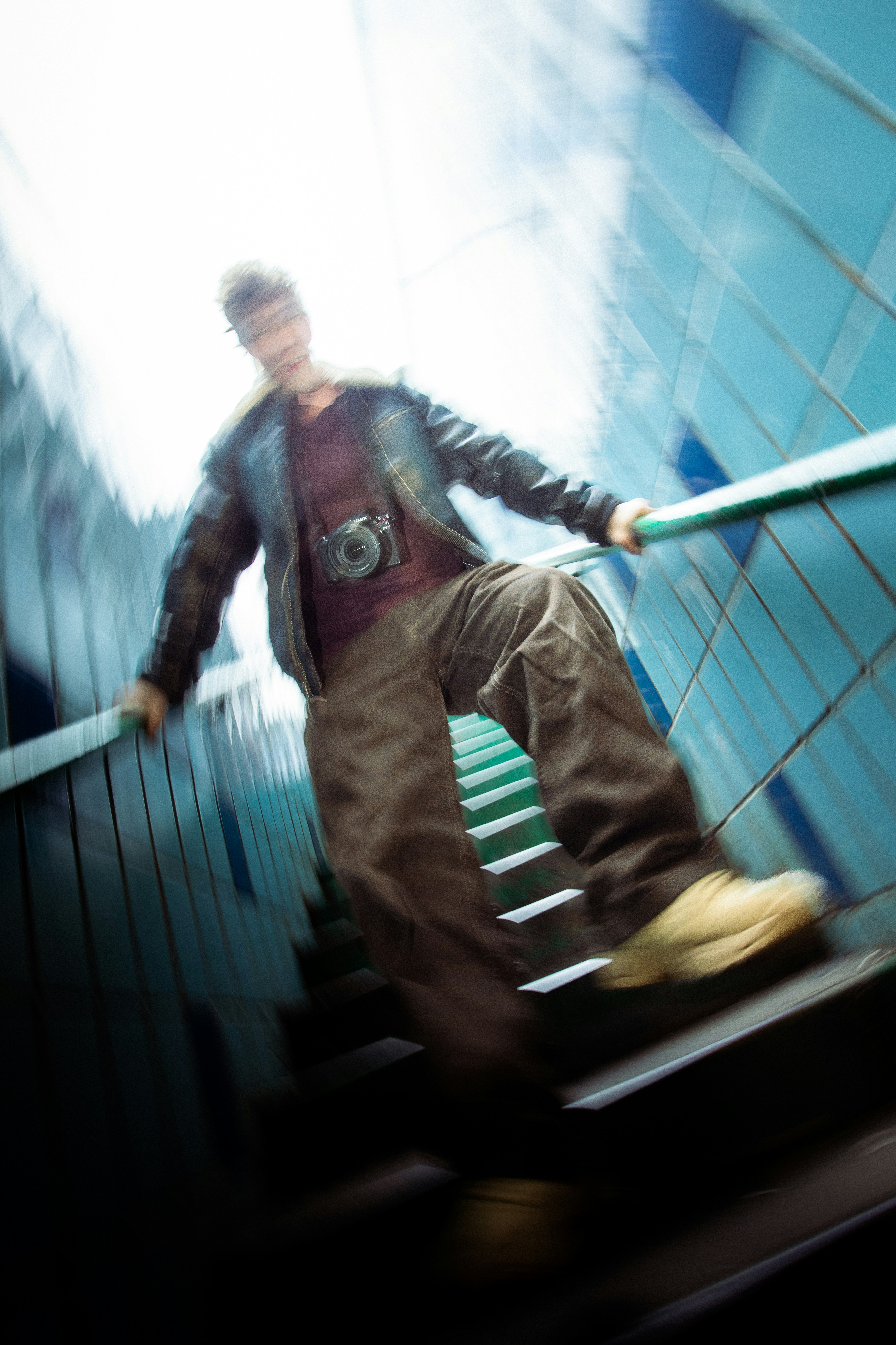 Man with camera going down stairs