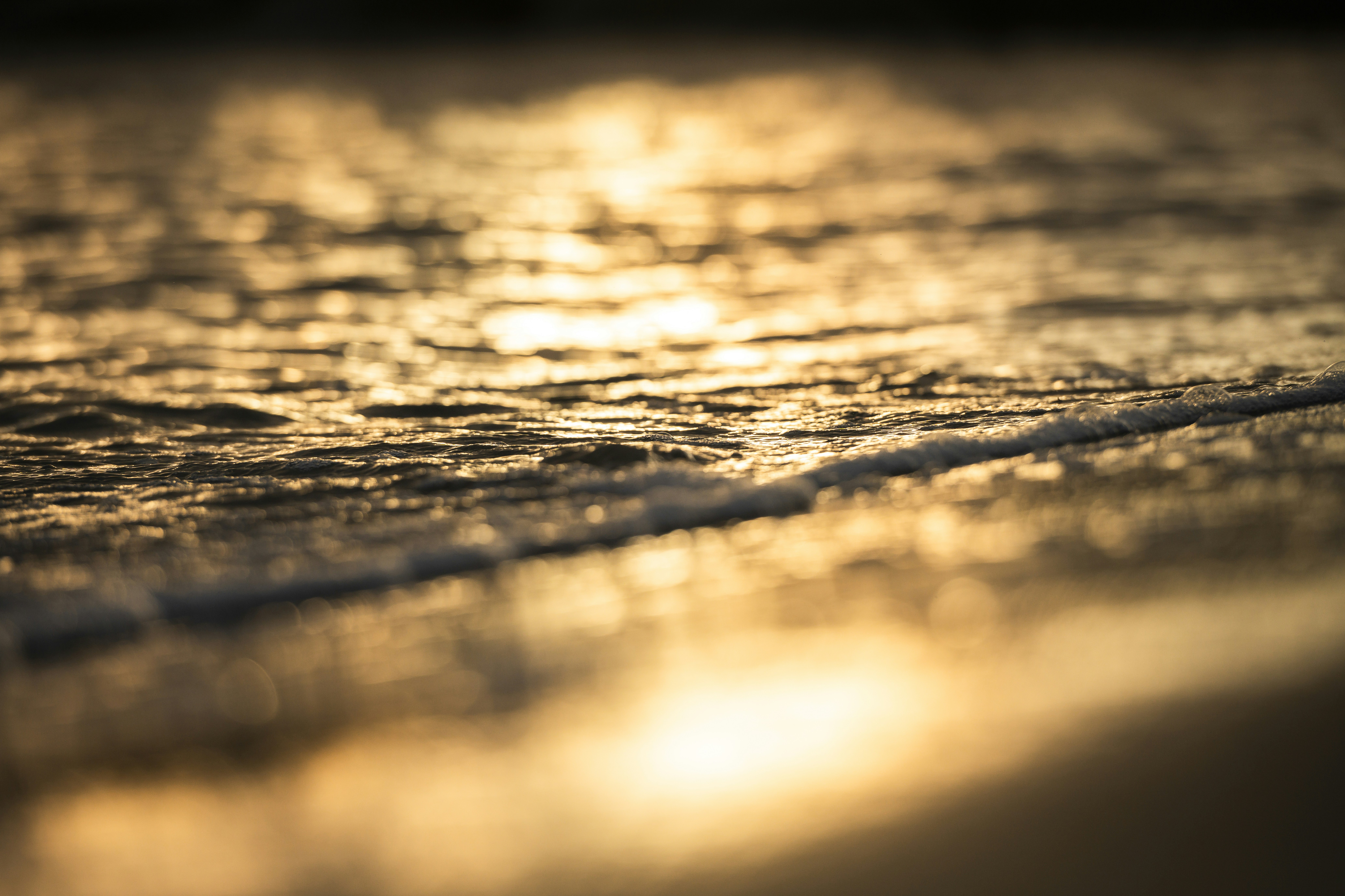 Golden ocean waves reflecting sunset light