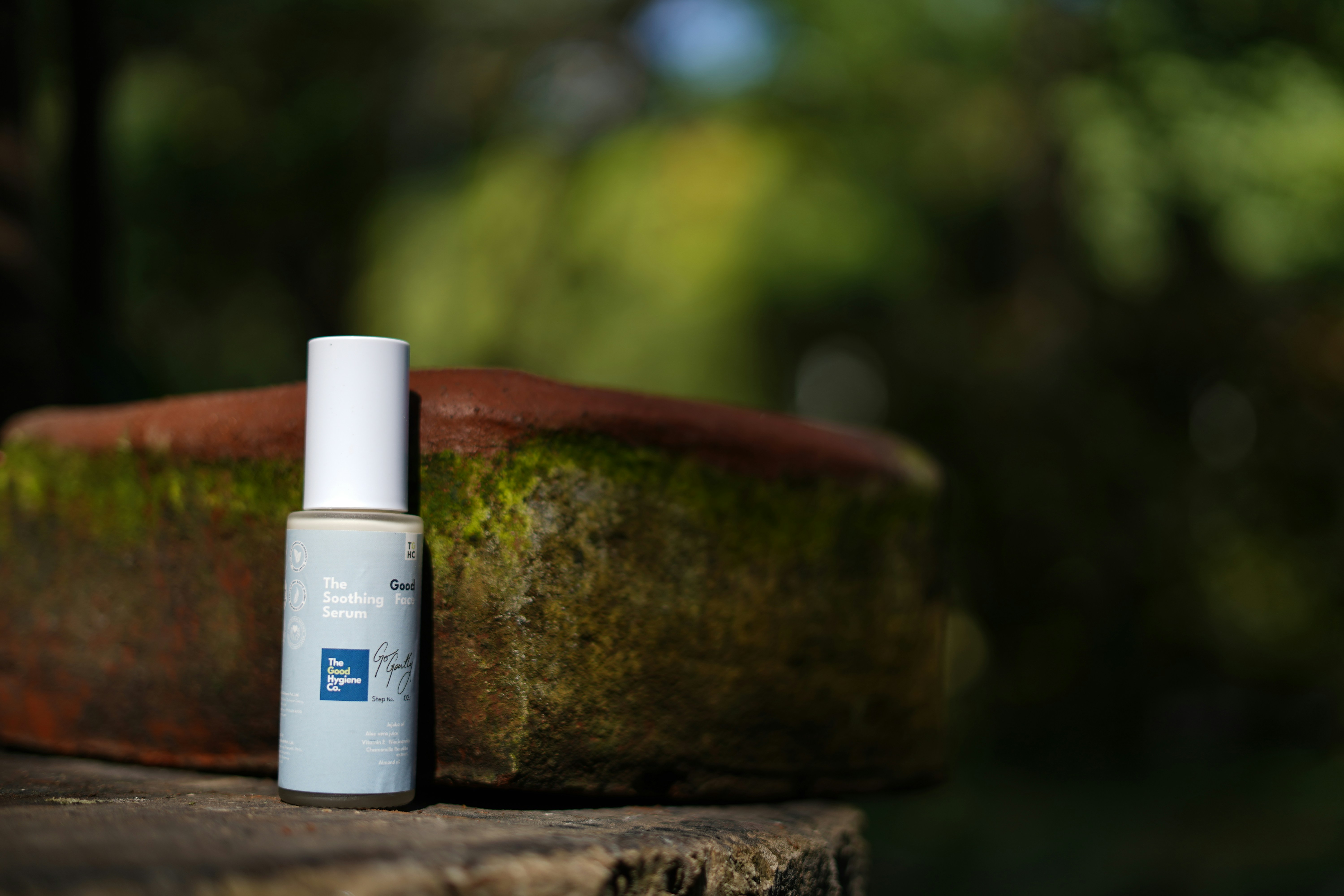 sunscreen SPF bottle product shot - Small bottle with blue label on mossy surface