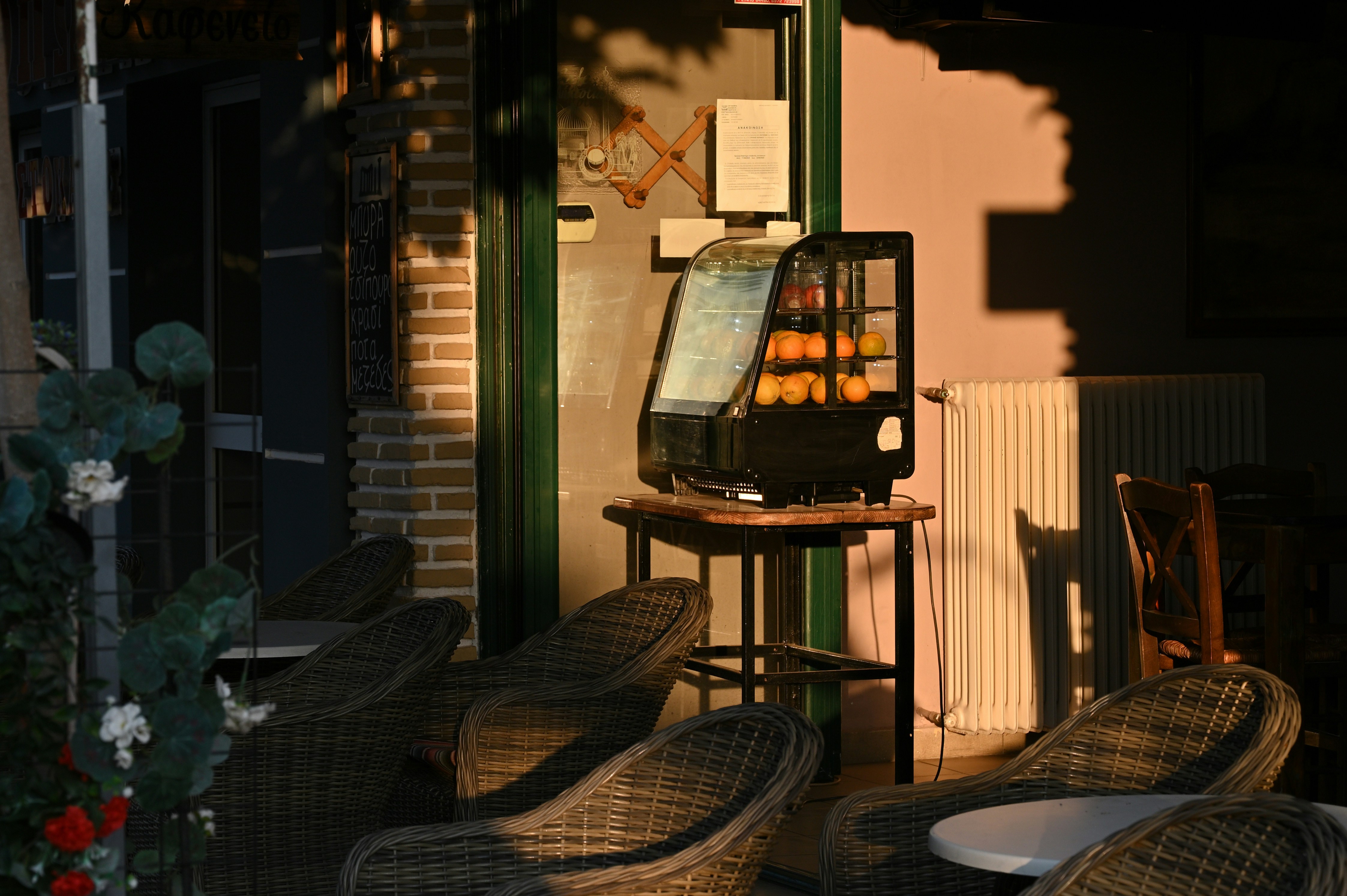 Outdoor cafe seating with display case of oranges