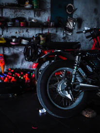 Two motorcycles parked in a dimly lit workshop.