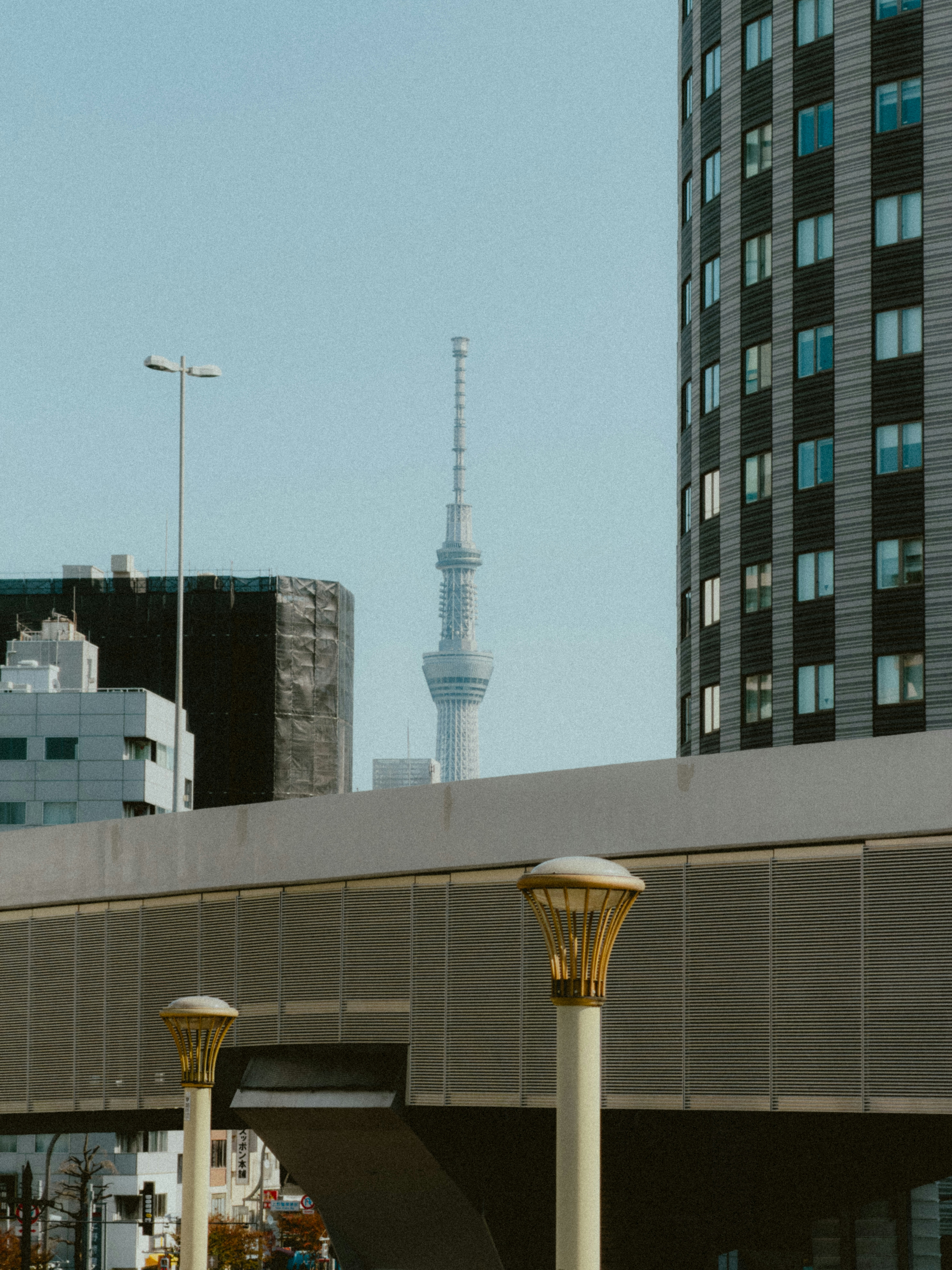 Tall tower amidst modern city buildings