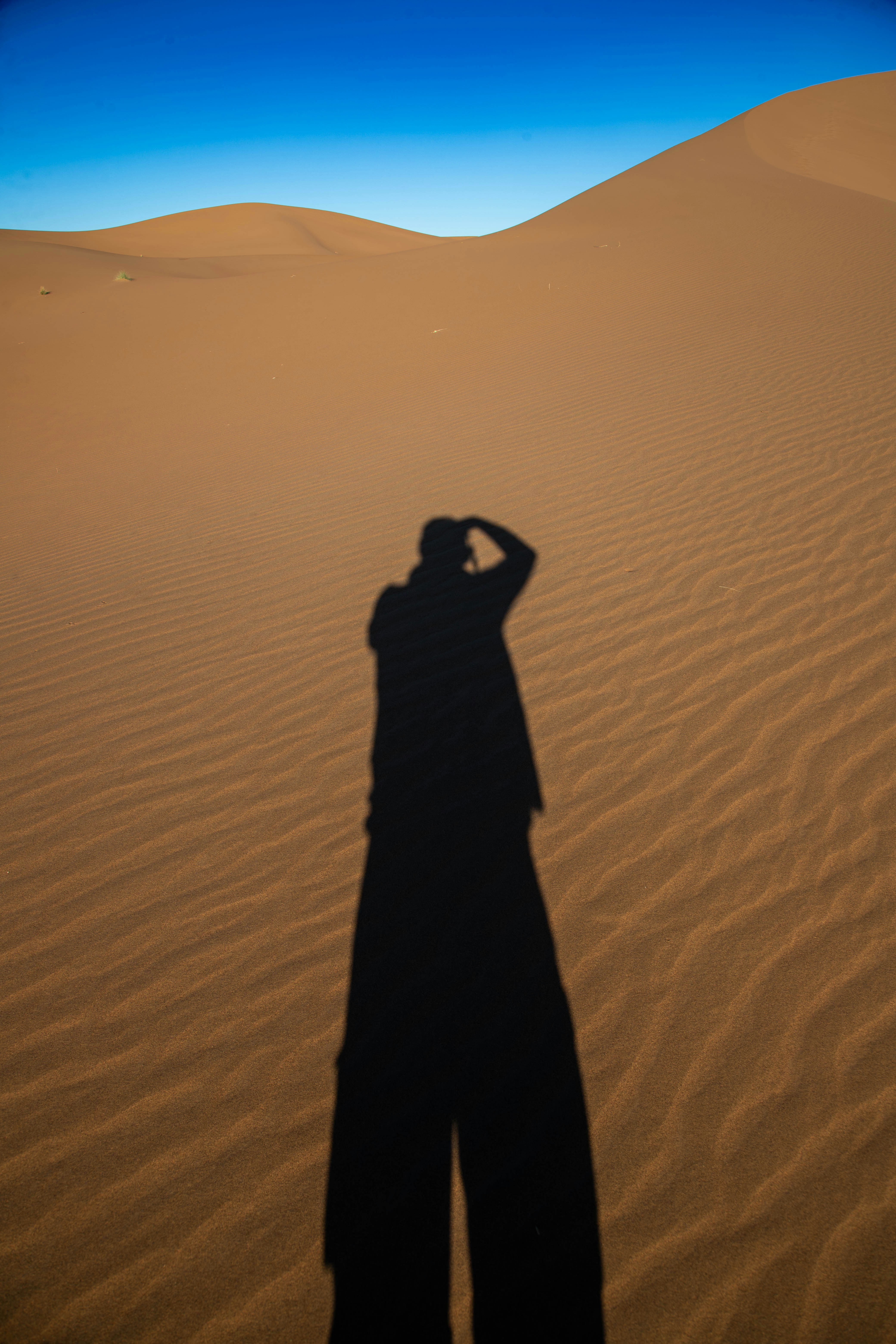 Shadow of a person taking a photo in the desert