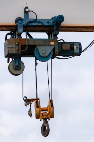 Industrial overhead crane with yellow hook and motor