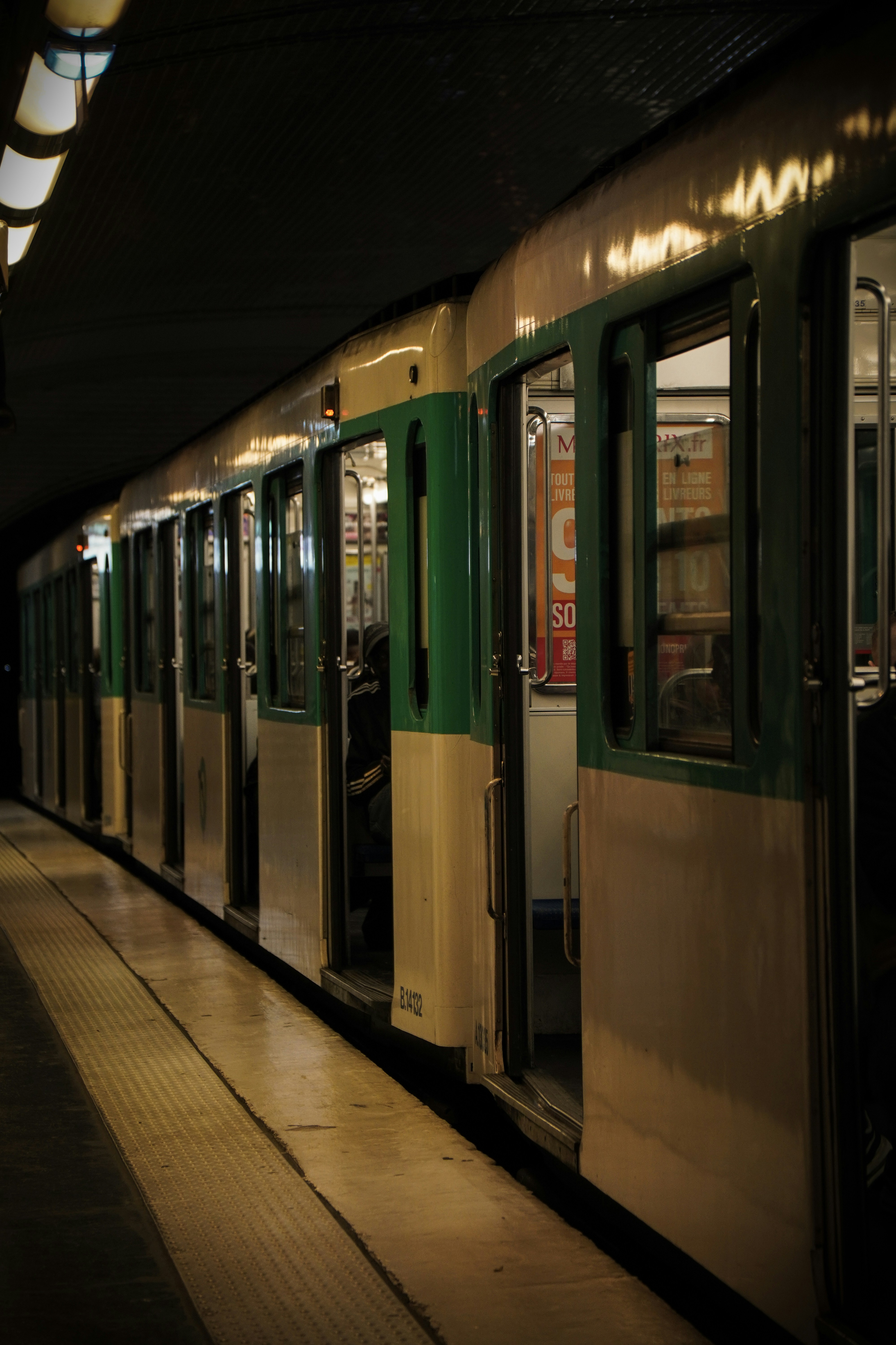 Train stopped at a dimly-lit European subway station at night