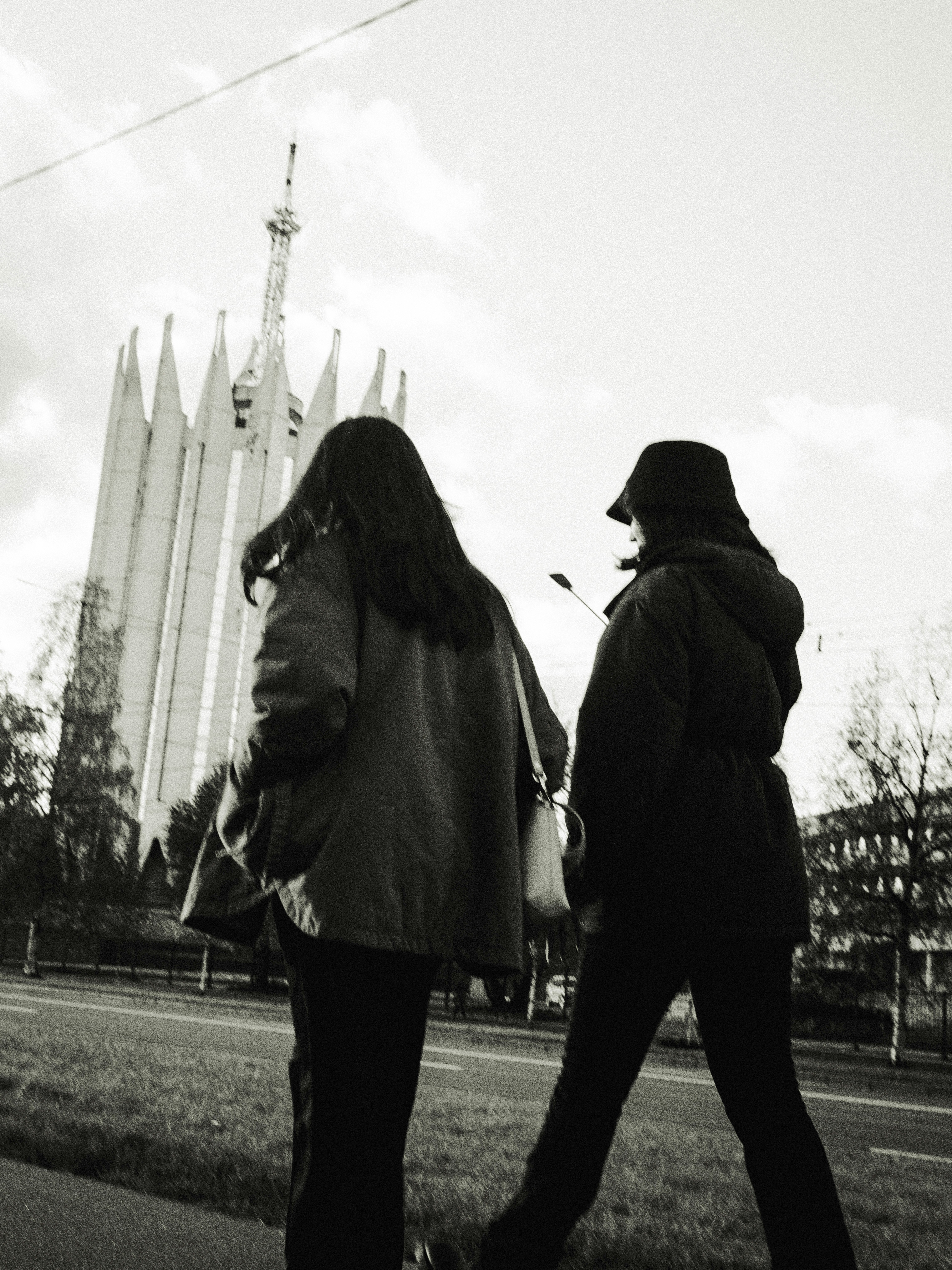 Dos personas pasan por delante de un edificio alto.