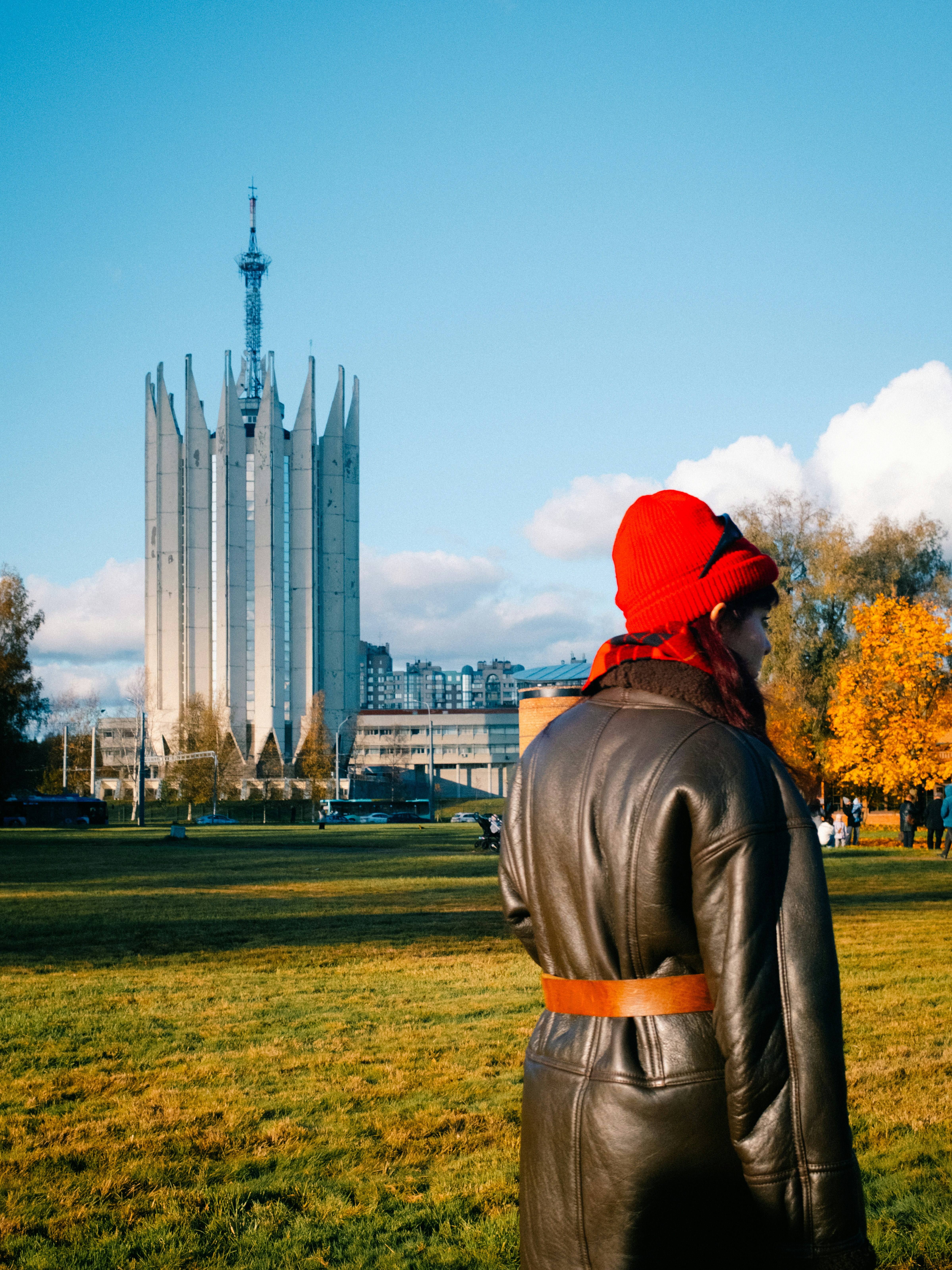 Mujer con sombrero rojo cerca de un edificio alto