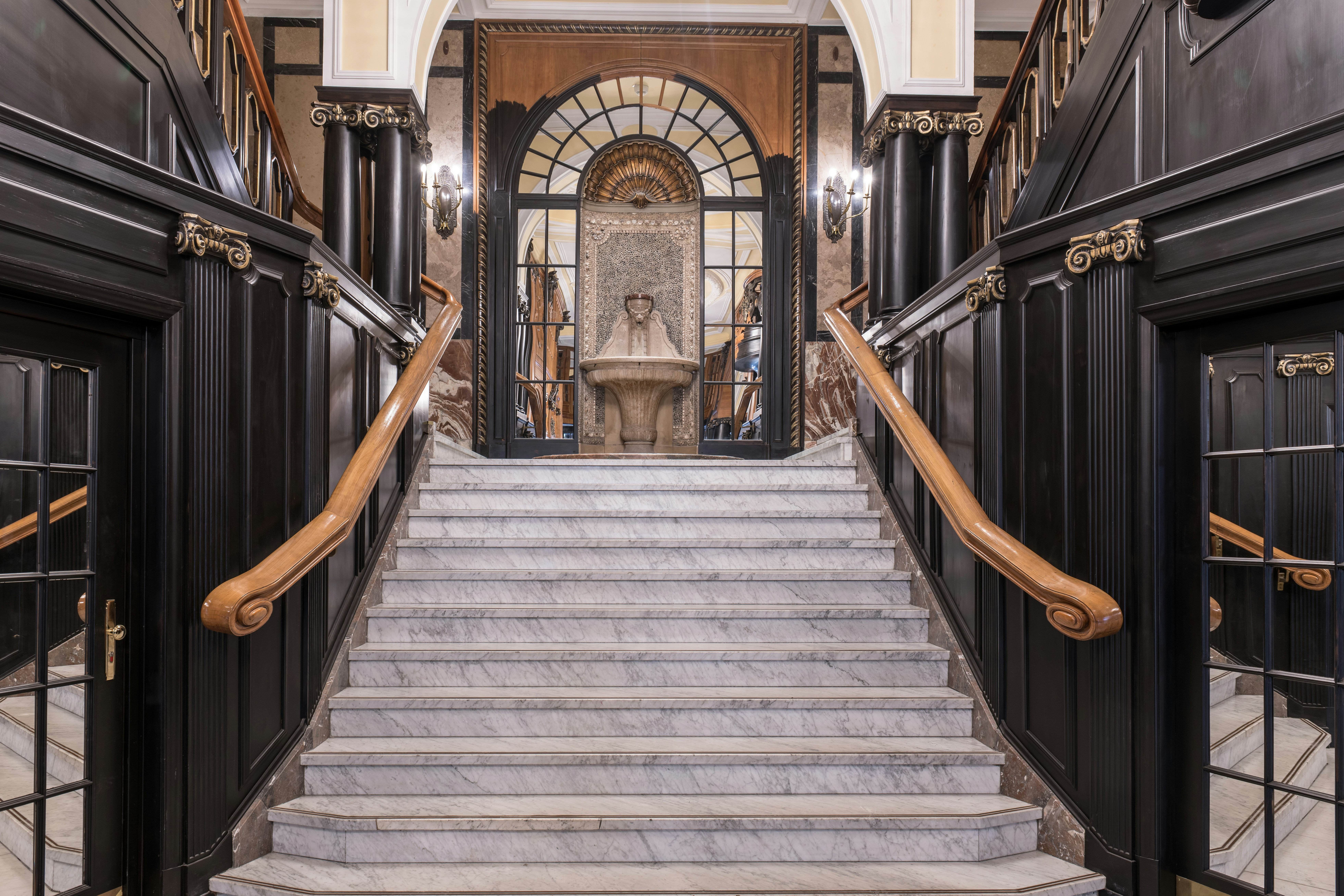 Elegant marble staircase with dark wood paneling and ornate details