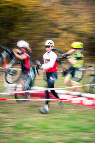 Cyclists running with bicycles during a race.