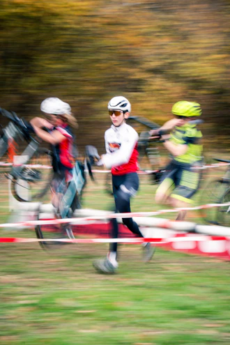 Cyclists running with bicycles during a race.