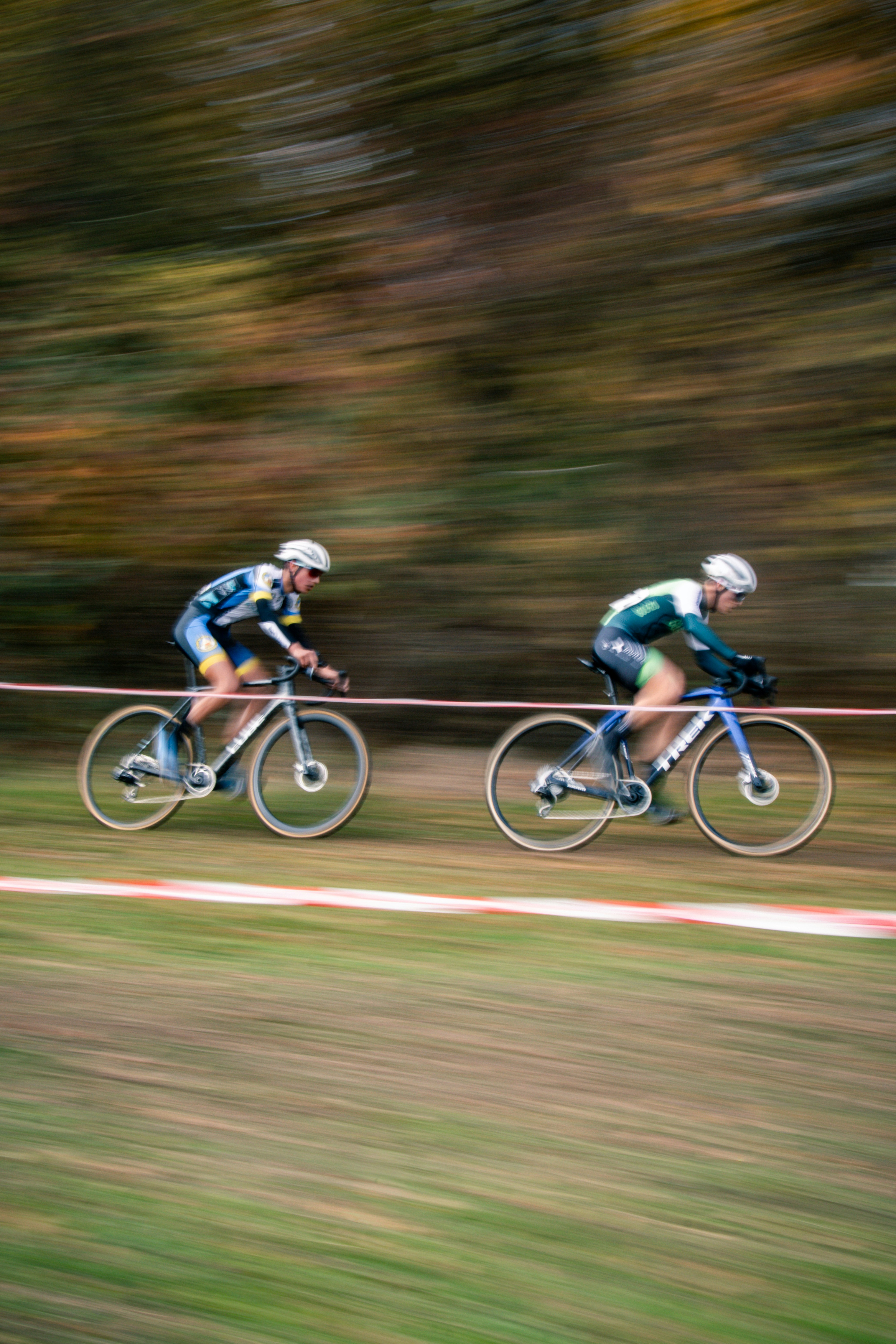Two cyclists race on a grassy track