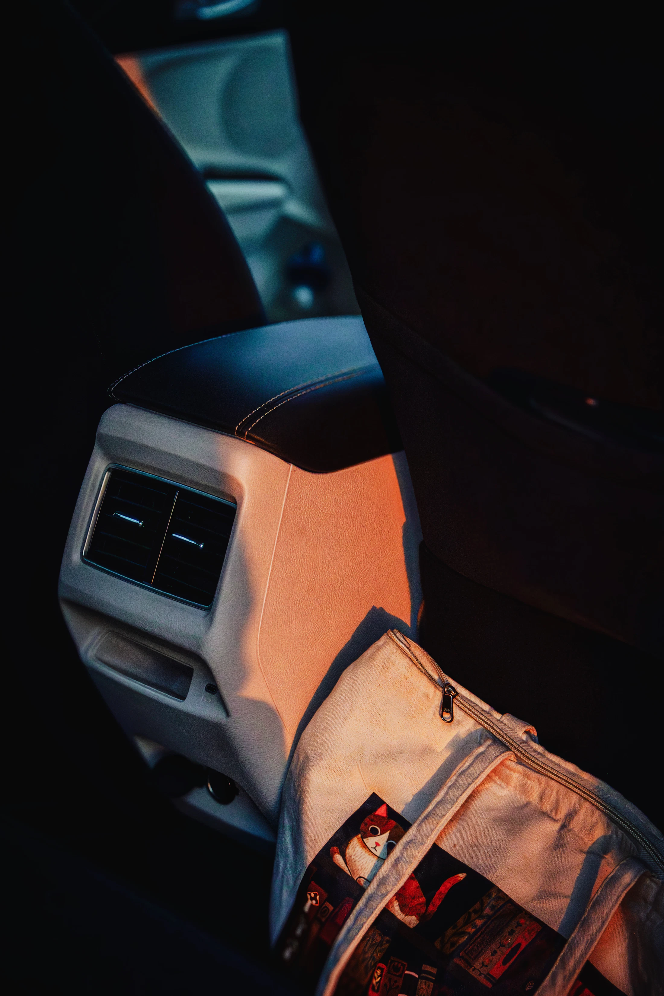 Car rear seat with a travel bag in warm natural light