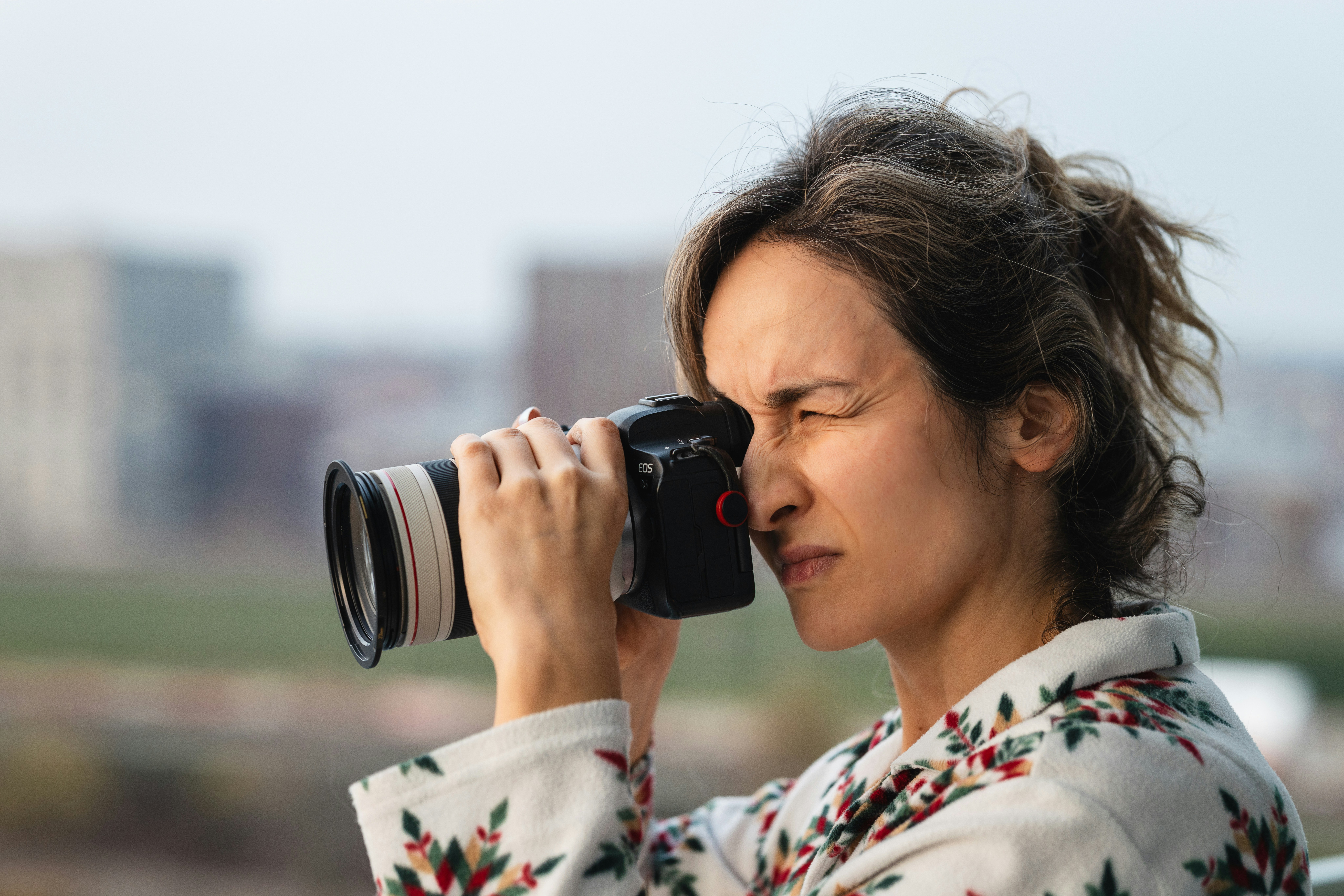 Woman looking through a camera viewfinder