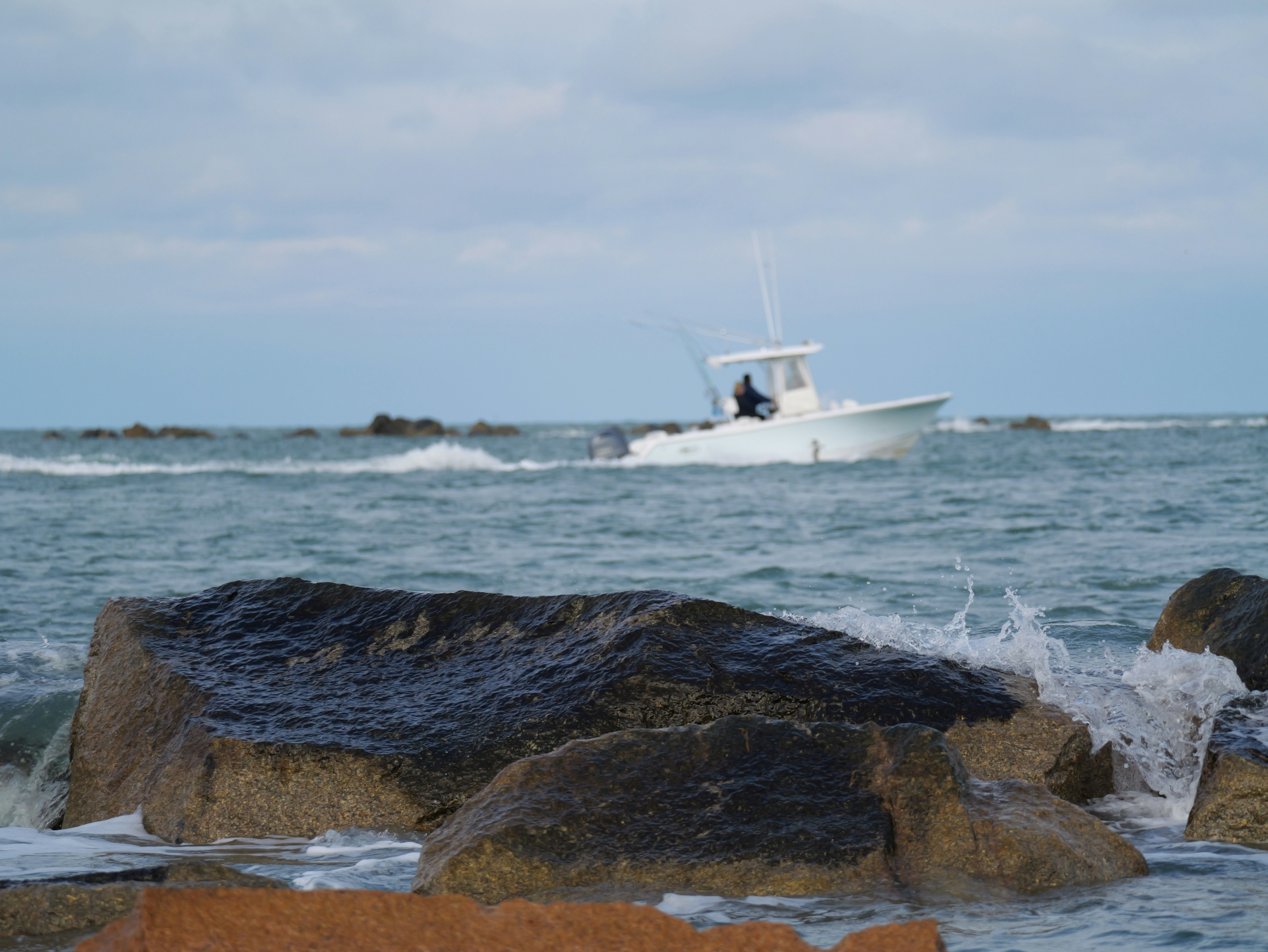 White boat sailing on choppy ocean waves