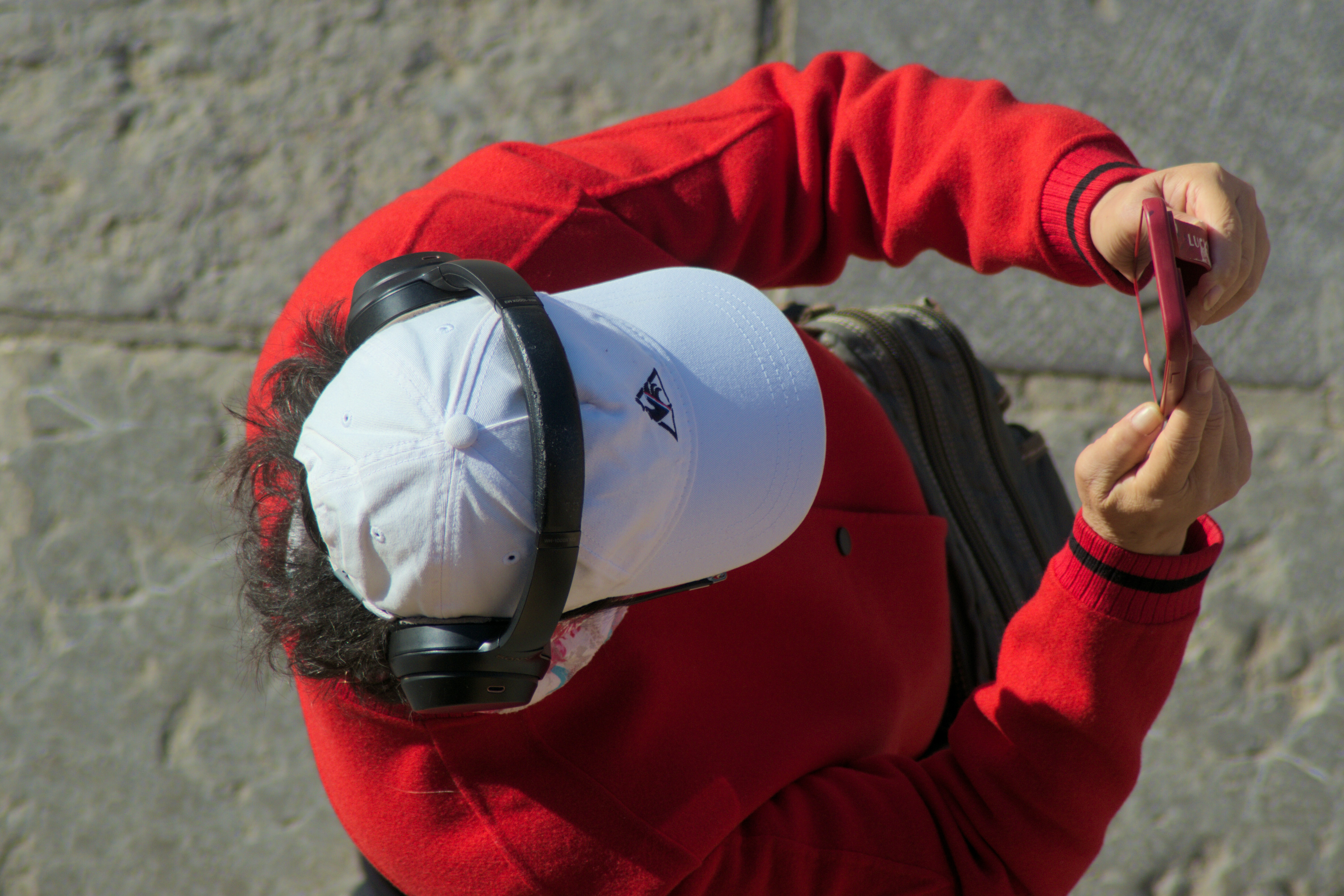 Person in red jacket taking a selfie with phone