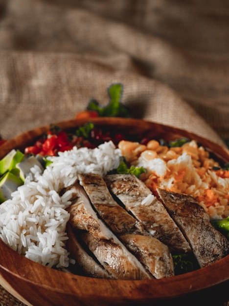 Sliced grilled chicken breast with rice and salad