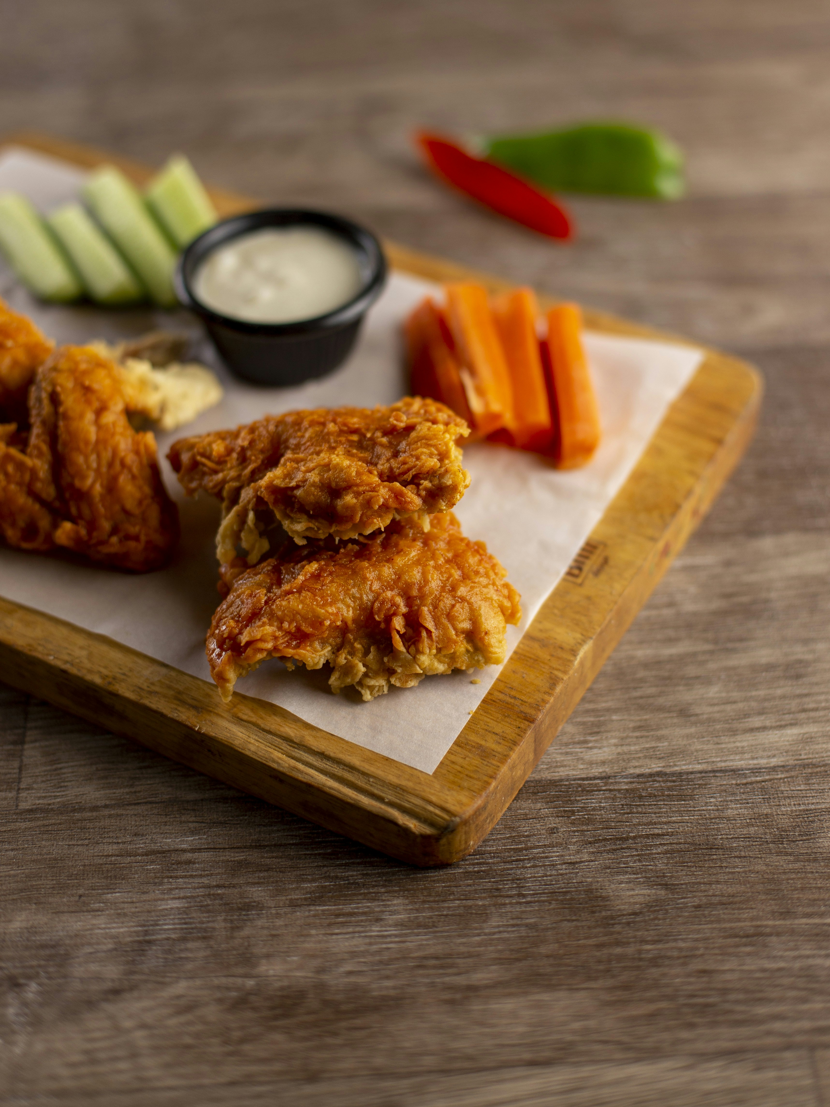 Crispy chicken wings with dipping sauce and vegetables