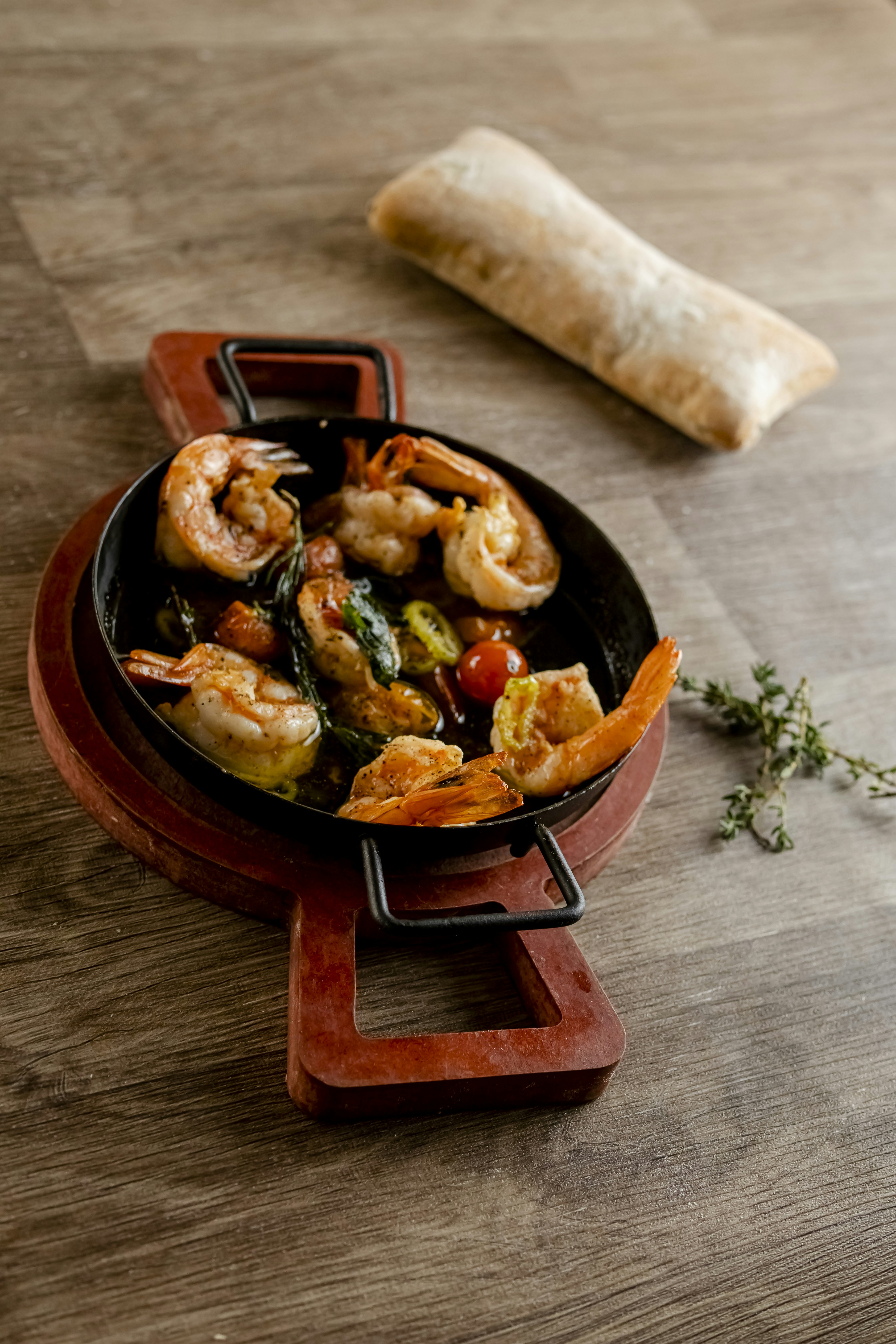 Shrimp dish served in a rustic pan with bread.