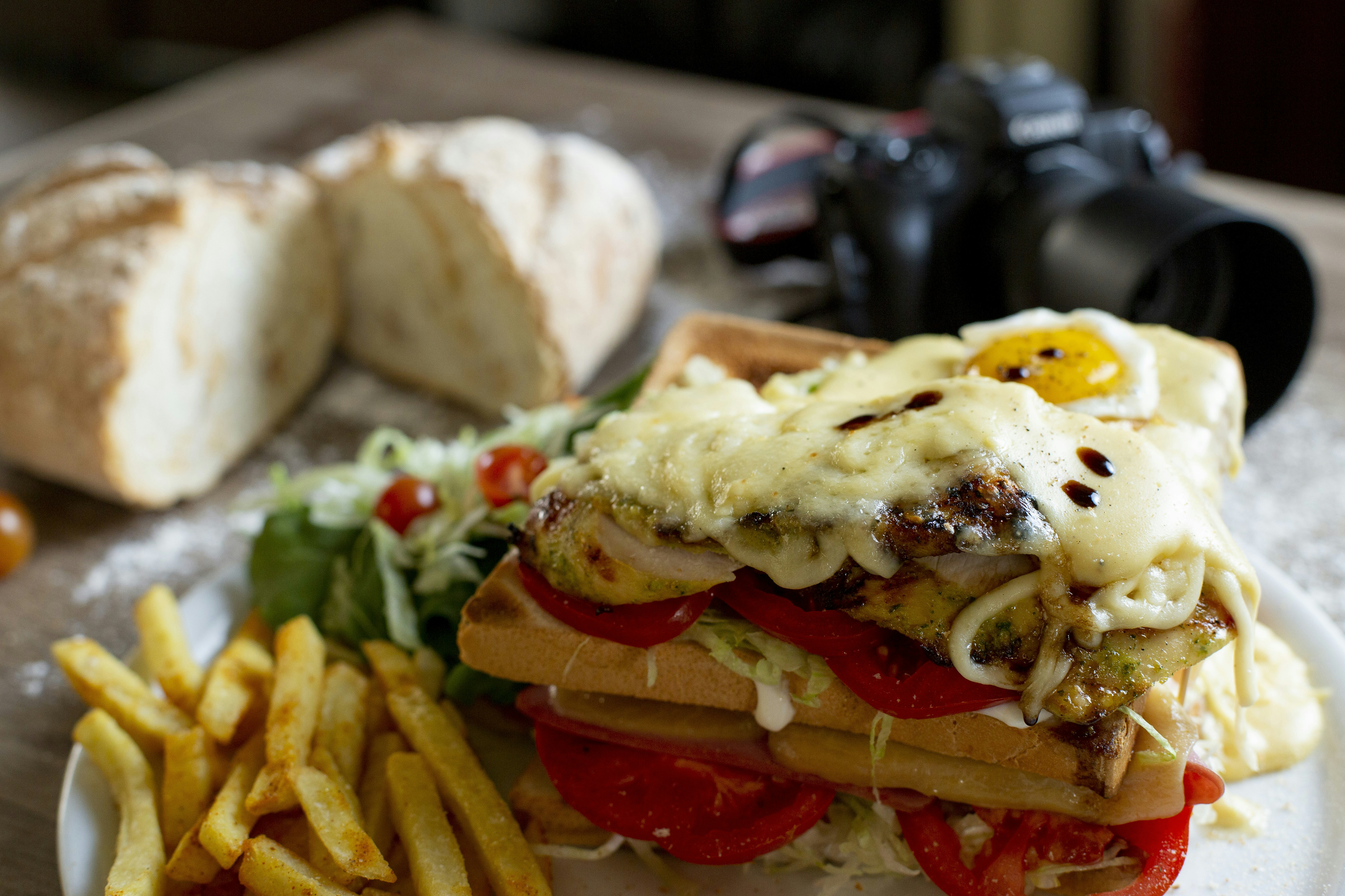 Waffle sandwich with fries, salad, and bread.
