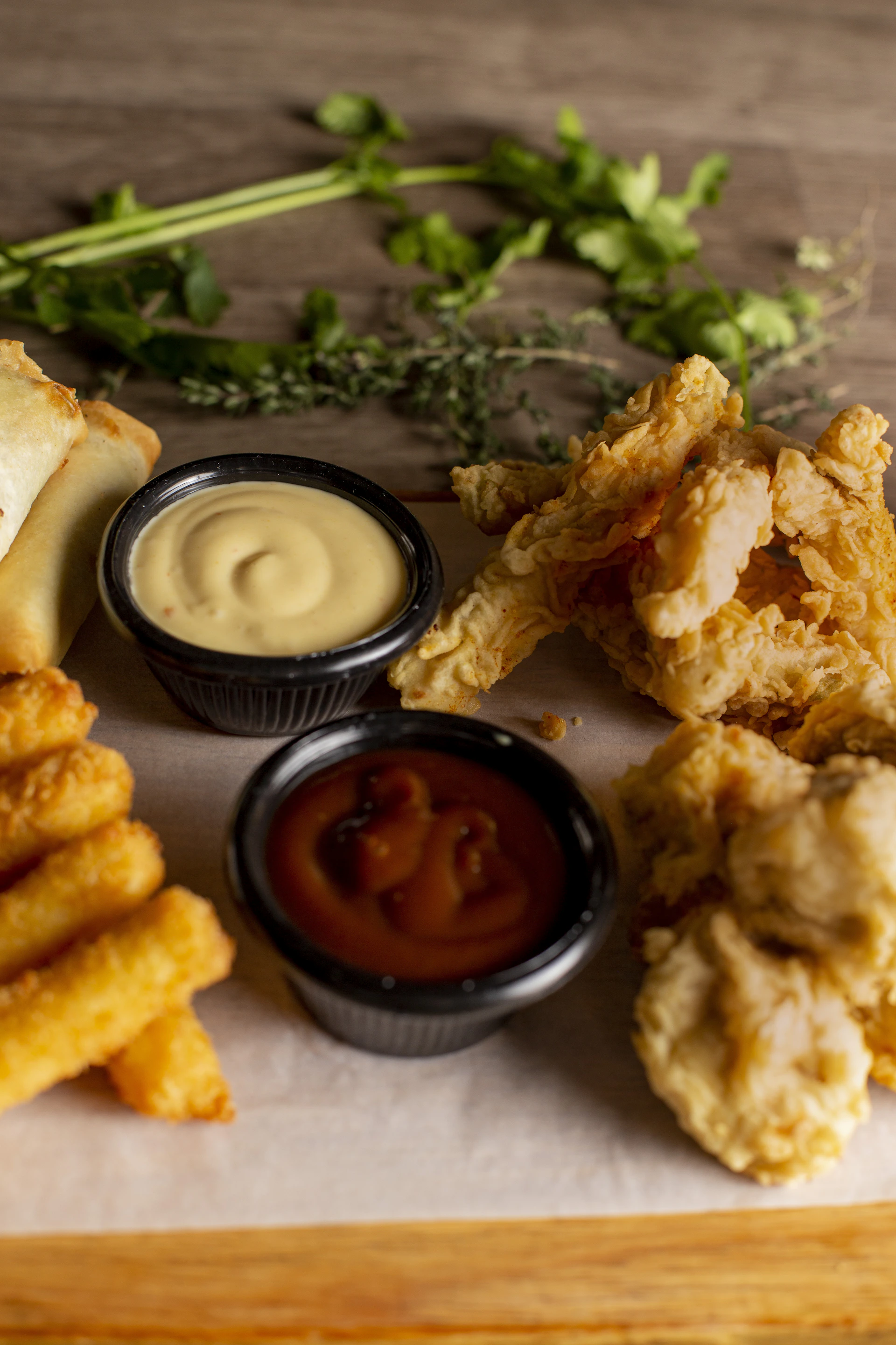 Fried appetizers with dipping sauces and herbs