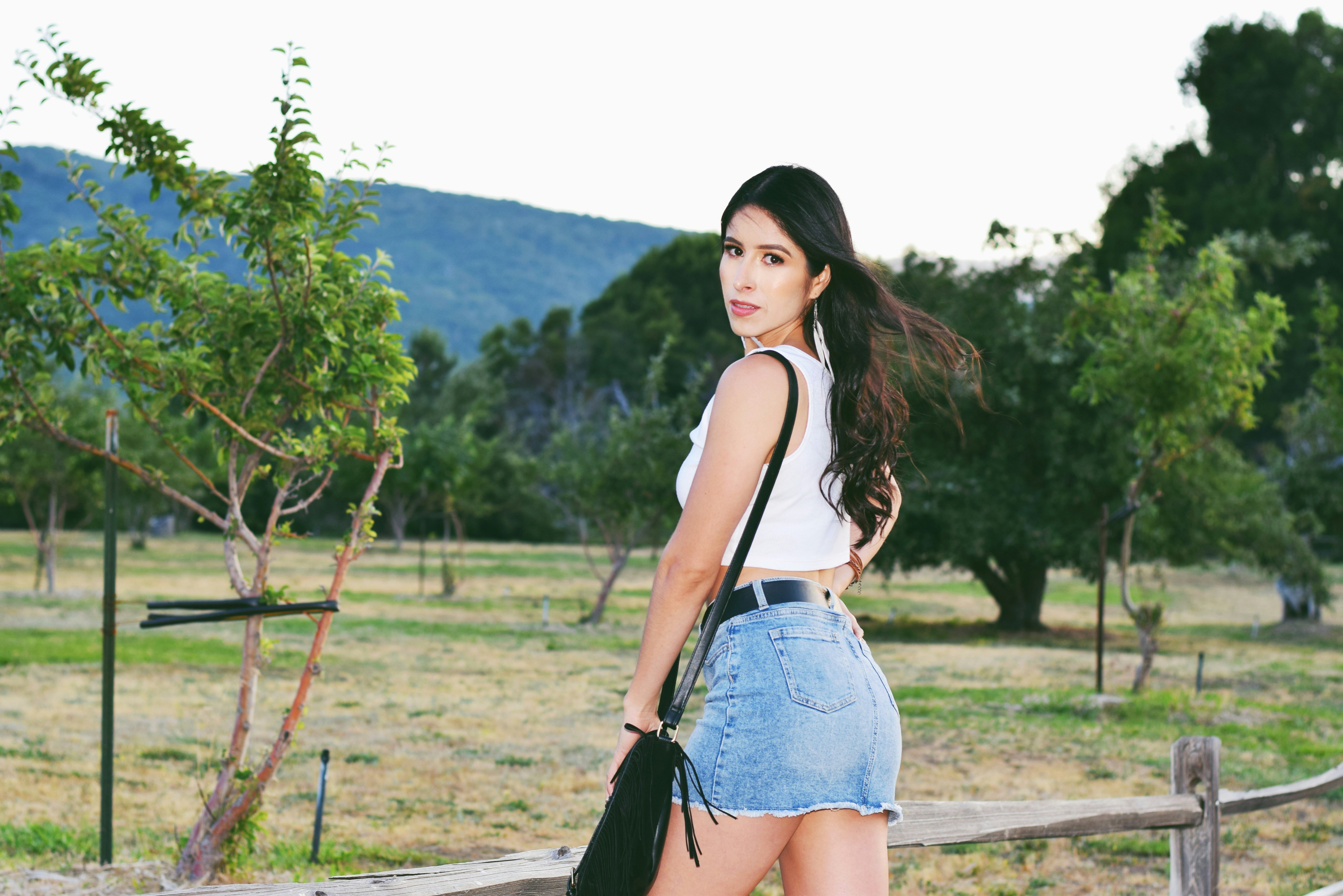 Young woman in denim skirt and crop top outdoors