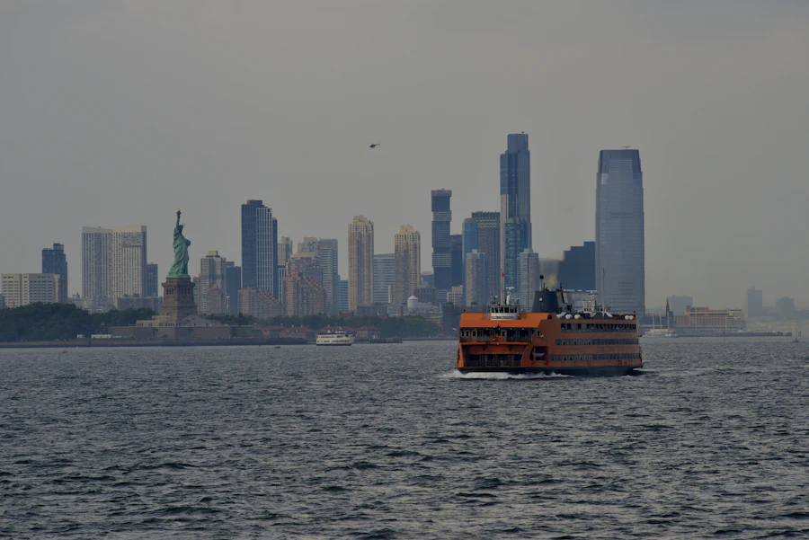 The Statue of Liberty with a boat and the New York City skyline
