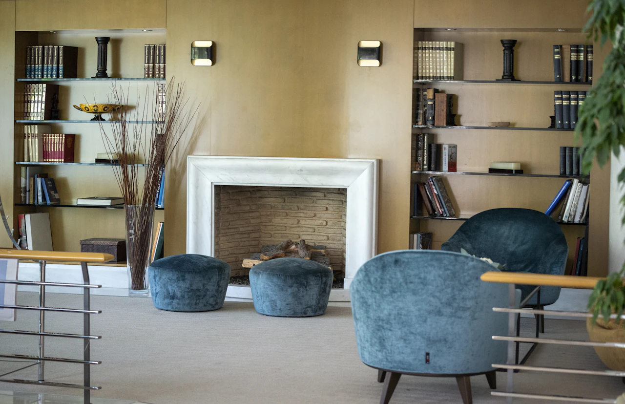 A cozy wood-panelled living room with a fireplace and bookshelves