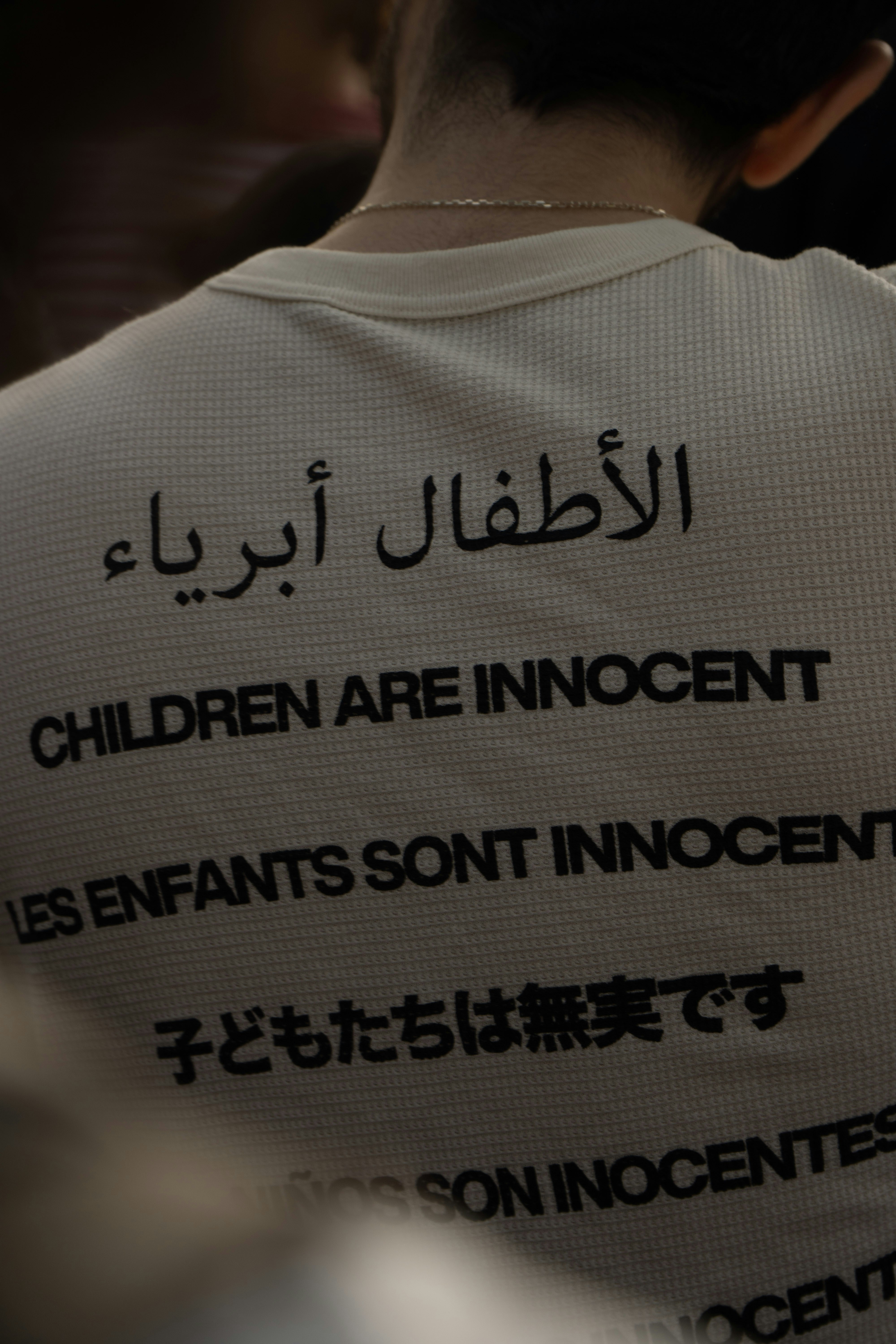 White shirt with text in multiple languages about innocence