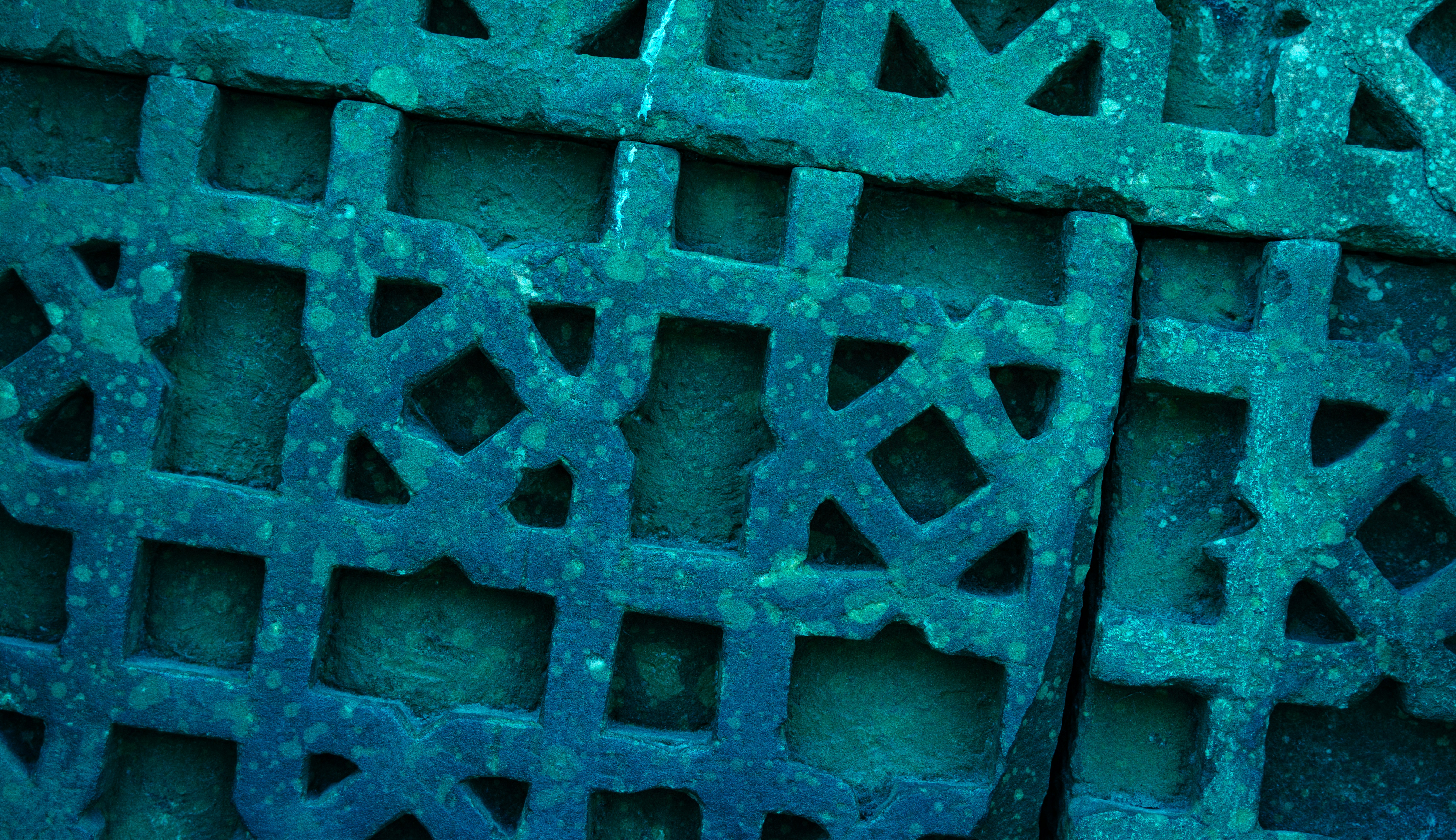Close-up of a teal-colored decorative metal grate